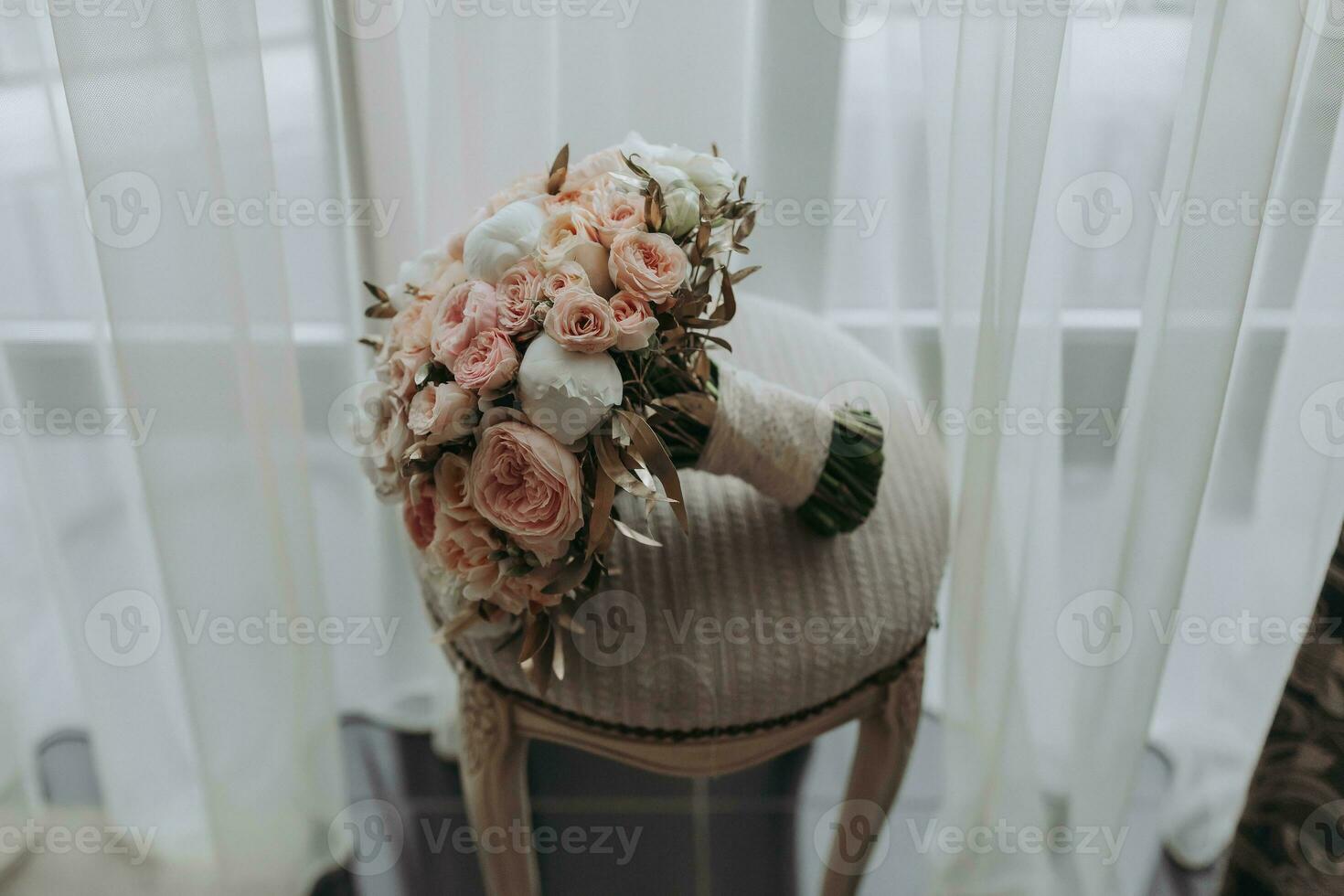 wedding bouquet of roses and various flowers on a chair in the wedding room photo