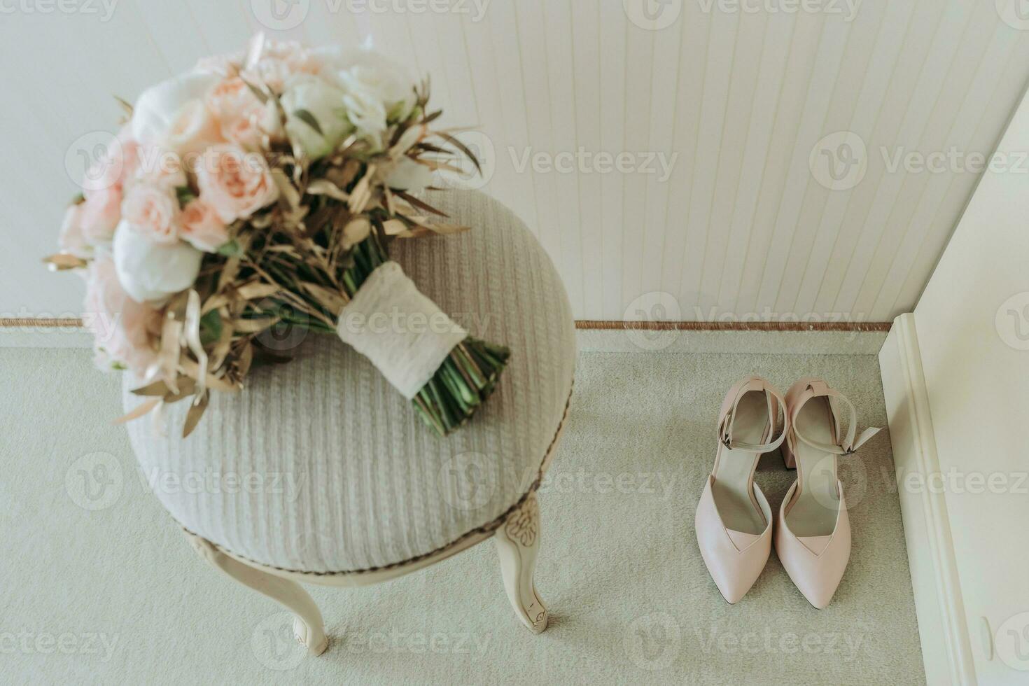 Boda ramo de flores de rosas y varios flores en un silla en el Boda habitación. rosado tacones altos De las mujeres Zapatos en el piso foto