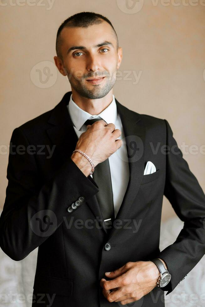 elegante hombre en un negro clásico traje con un atar. el novio es preparando para el Boda ceremonia foto