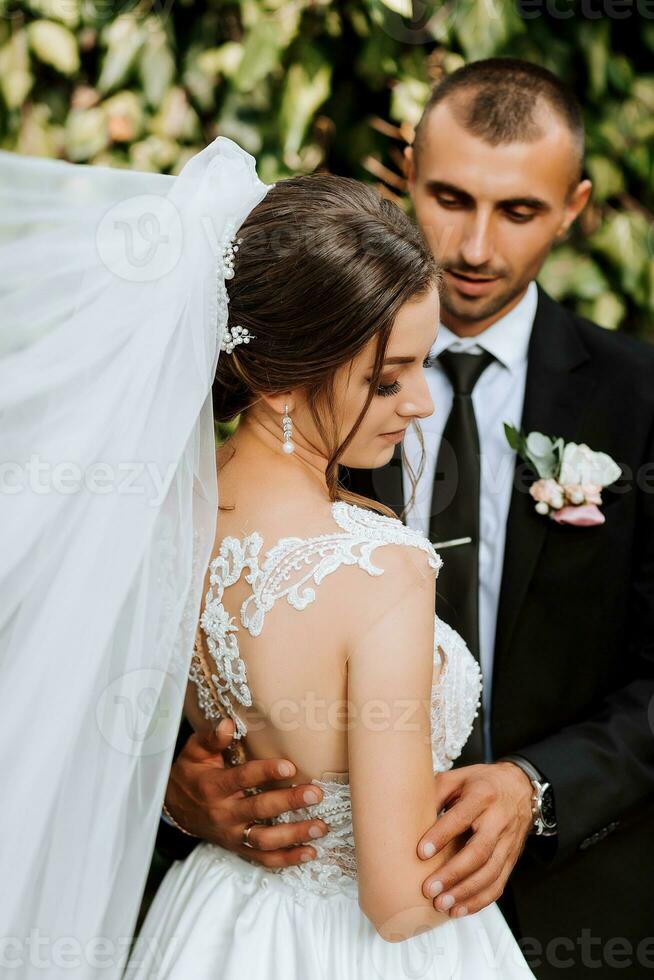 Young wedding couple enjoying romantic moments outdoors in autumn park under sunlight photo