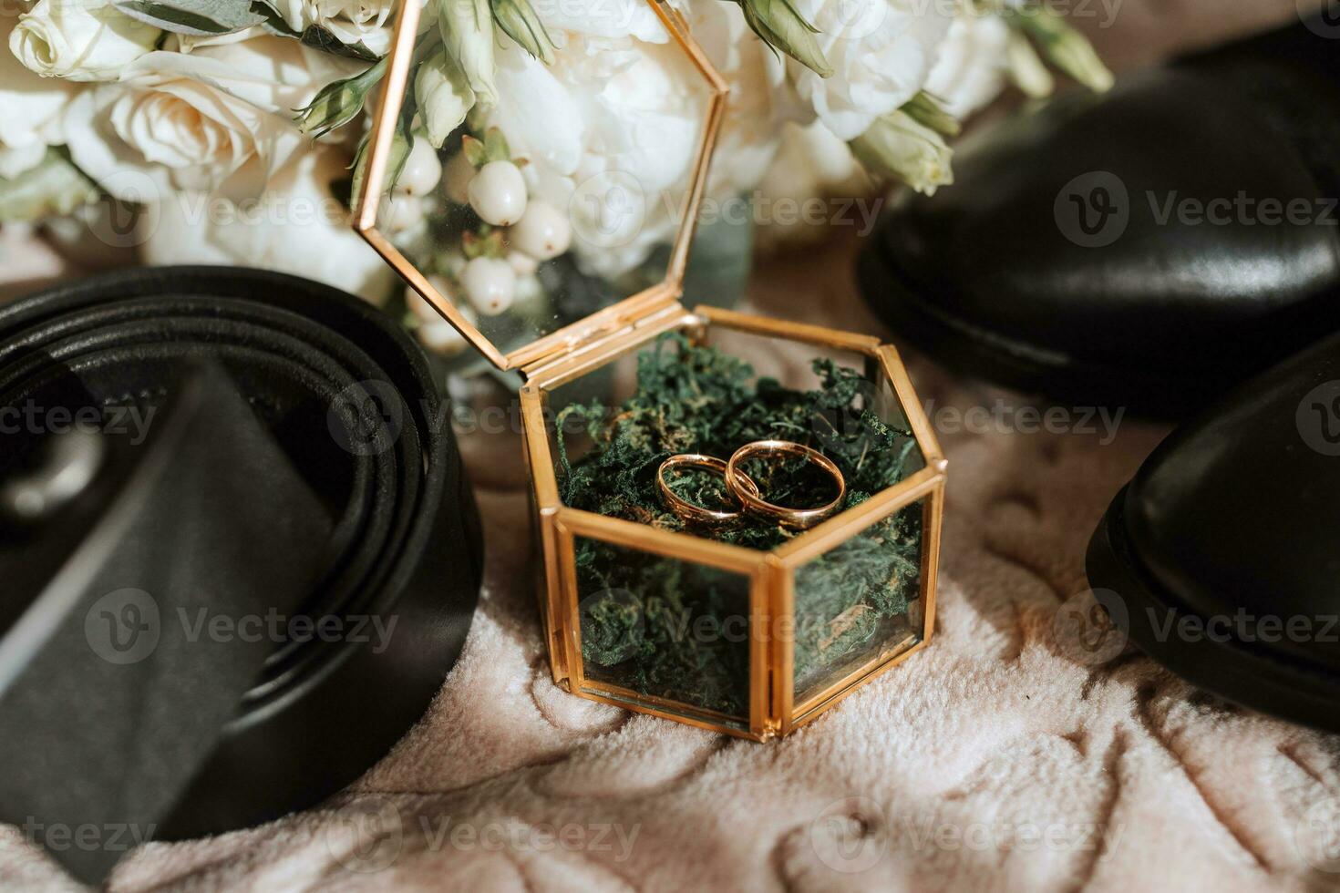 wedding rings lie in a beautiful glass box on green moss. Details of the verb during the morning meeting photo