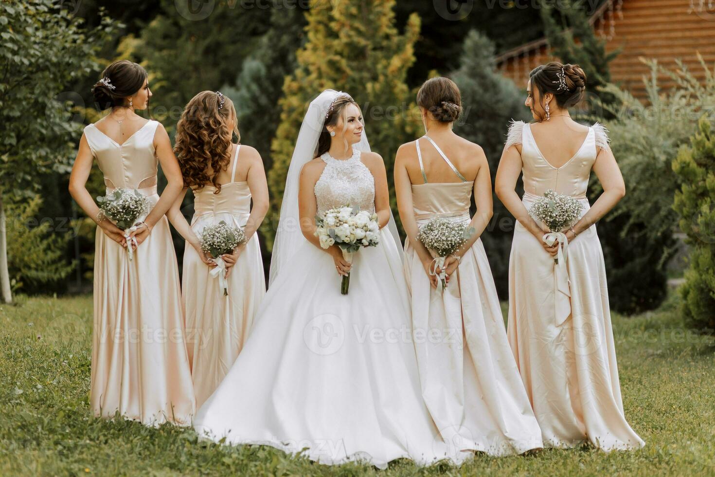 A group of beautiful women in matching dresses are smiling, celebrating, and having fun together. Friends of the bride in pink dresses celebrate the wedding together with the bride photo