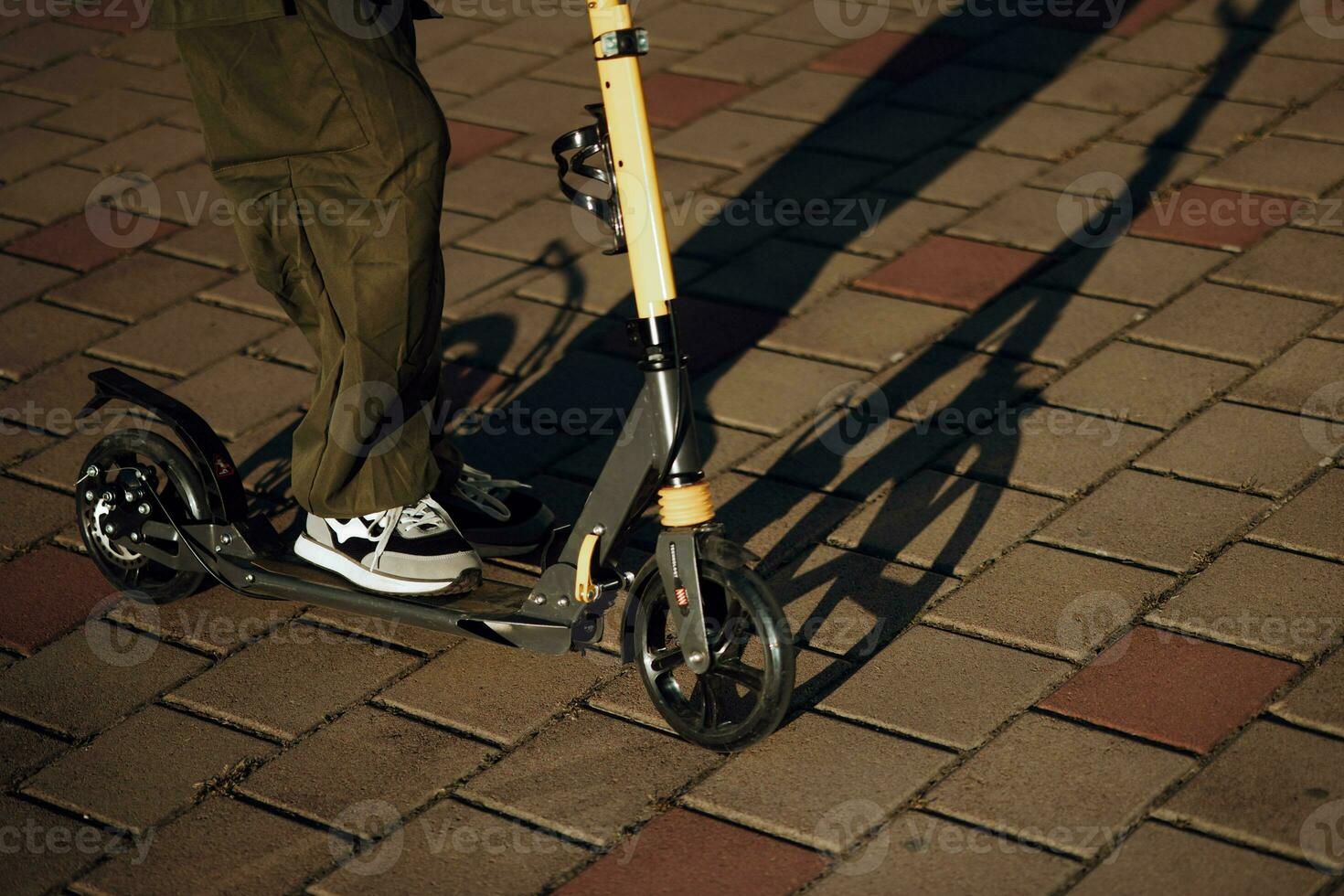 outdoor portrait of a young teenage girl riding a scooter close-up in a town square photo