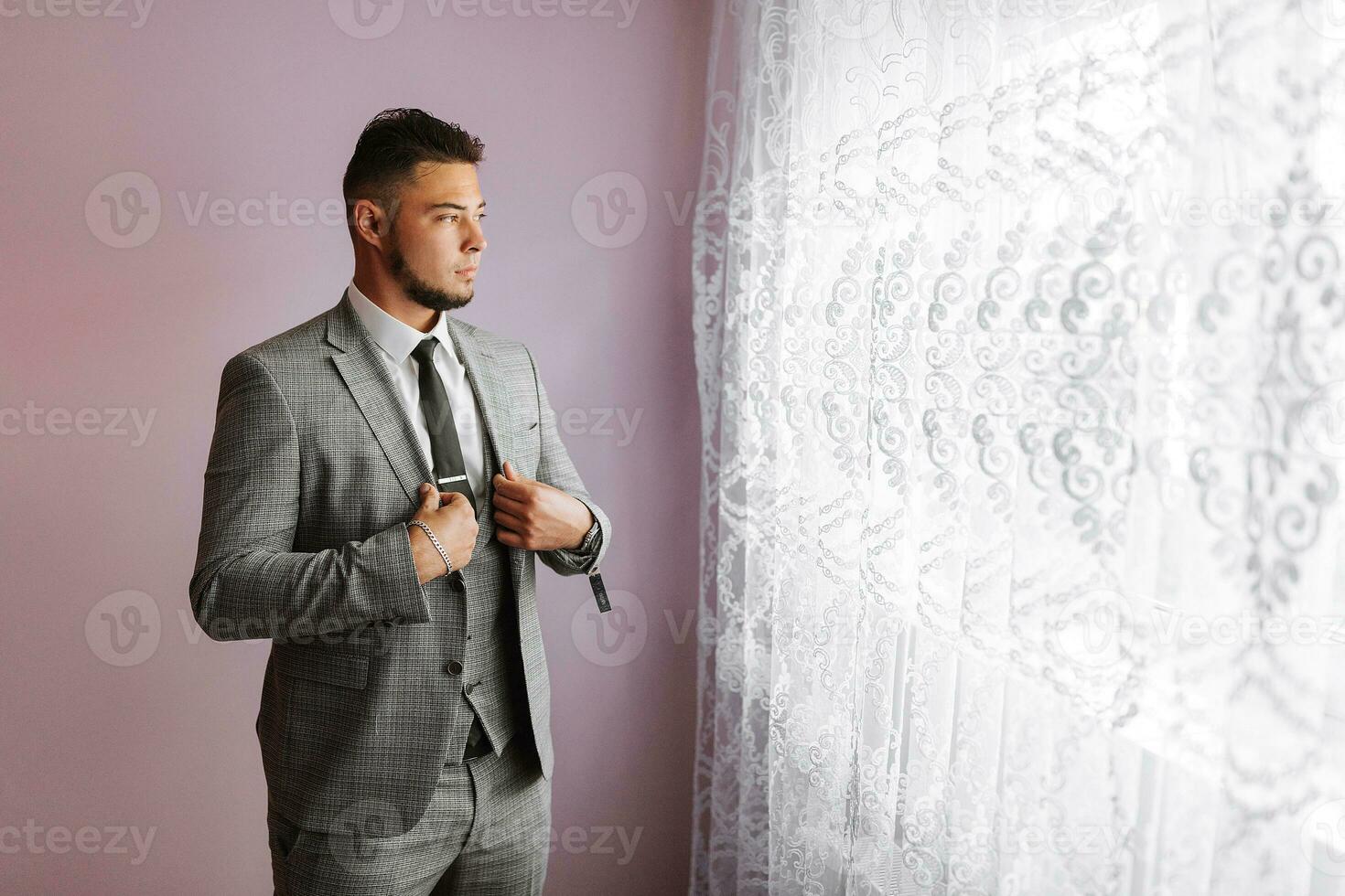 portrait of a man with a beard in a classic suit. The groom is preparing for the wedding. The man is wearing a white shirt and a suit. Stylish groom photo