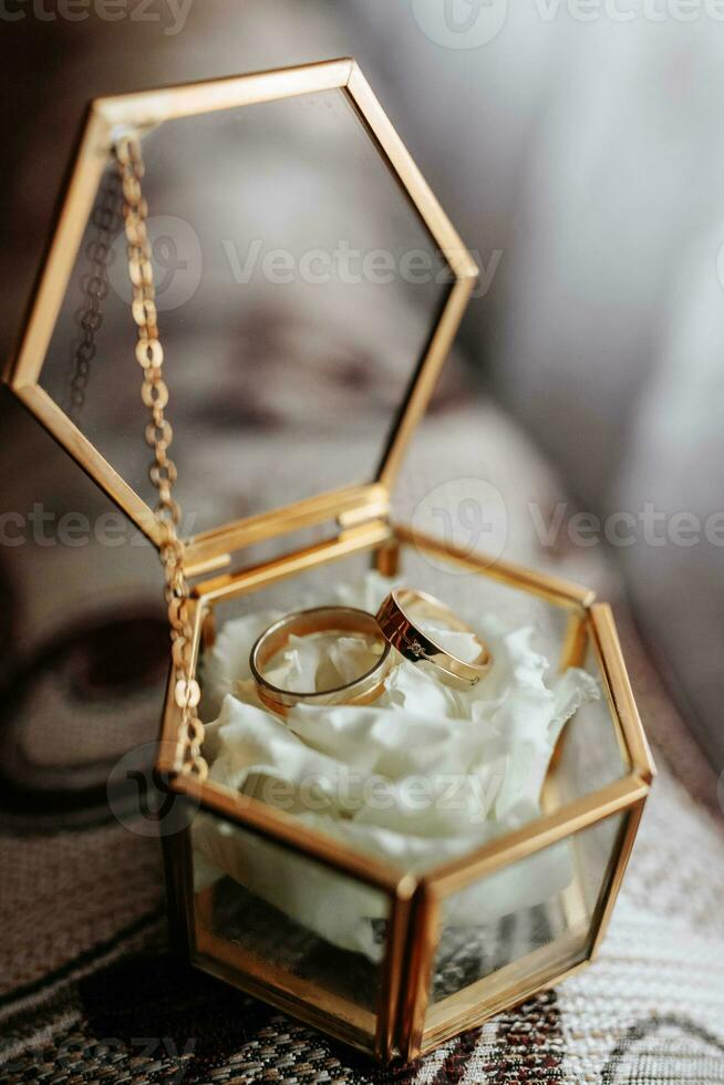 Glass box with wedding rings. Details of the groom photo