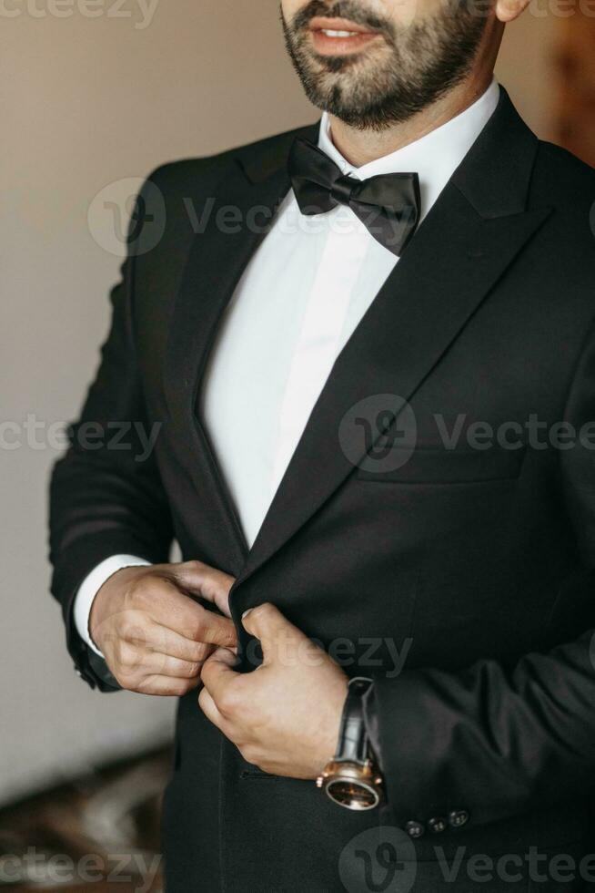 the man fastens the buttons on his jacket. The groom is preparing for the wedding ceremony. Detailed close-up photo of hands