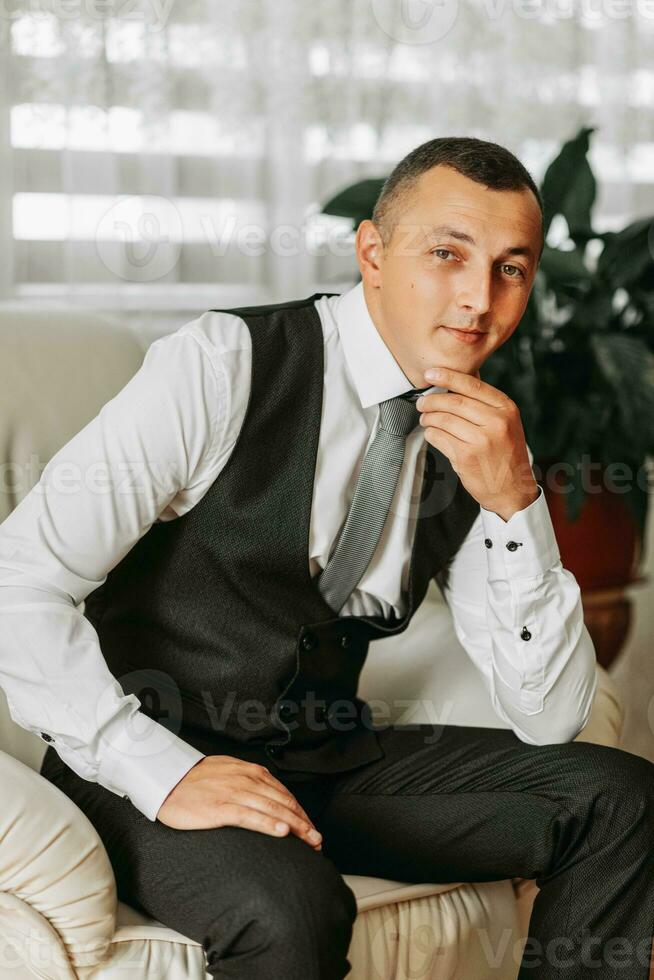 retrato de un hombre en un clásico traje. el novio es preparando para el boda. el hombre es vistiendo un blanco camisa. elegante novio foto