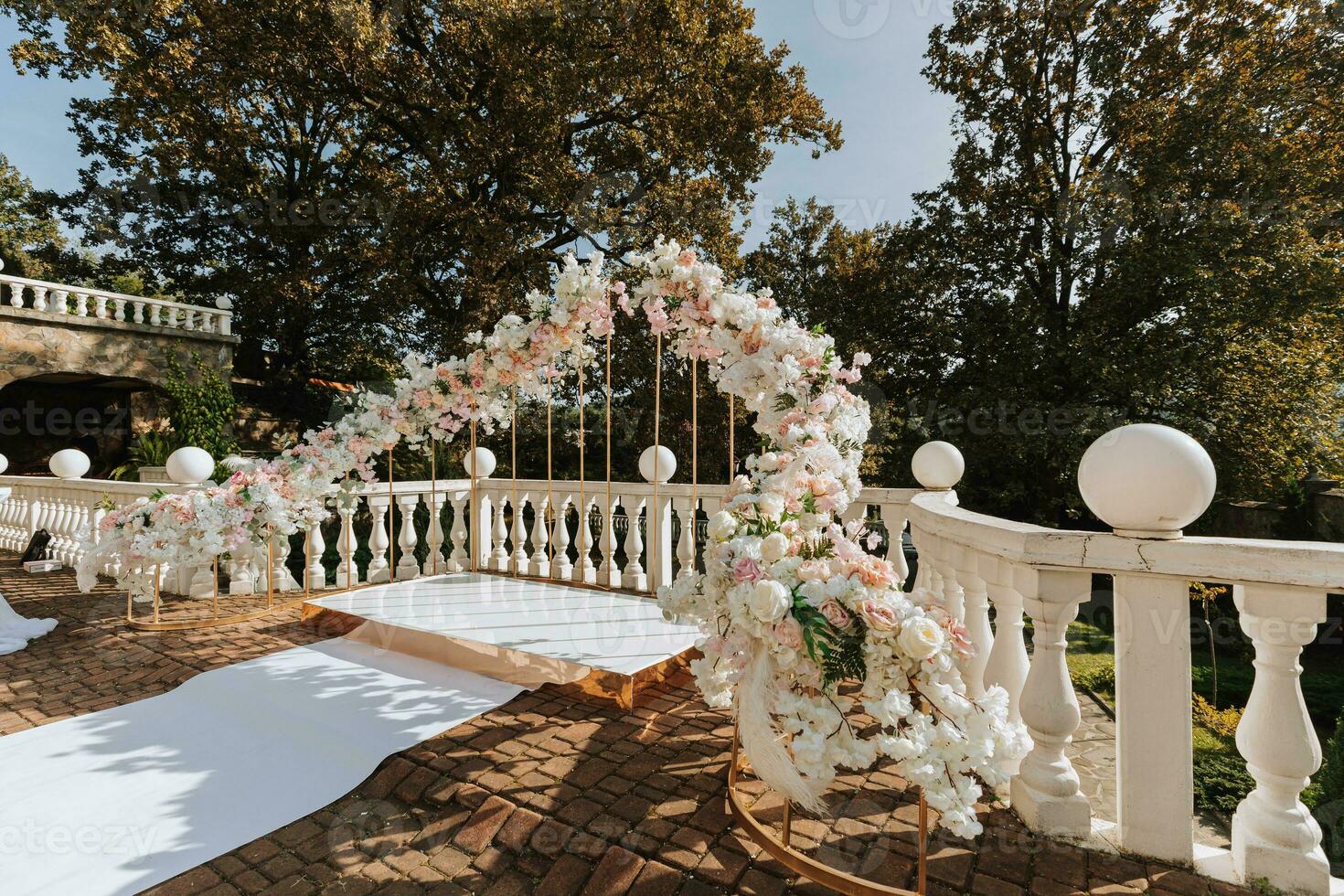 Modern ceremony in European style. Wedding arch with roses on the background of the forest. Jewelry made of fresh flowers, flowers and crystals. Front view. photo