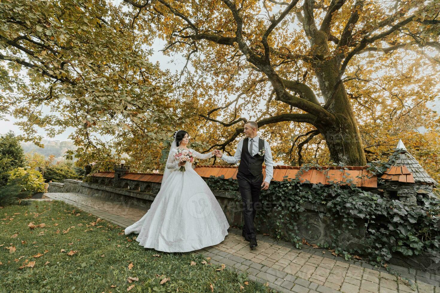 Full body portrait of a young bride and groom enjoying a romantic moment outside at sunset on a beautiful autumn day. Wedding couple. Standing face to face photo