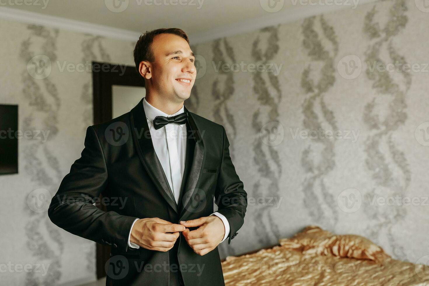 Preparation for the morning of the bride and groom. portrait photo of an elegant man getting dressed for a wedding celebration. The groom, dressed in a white shirt and bow tie