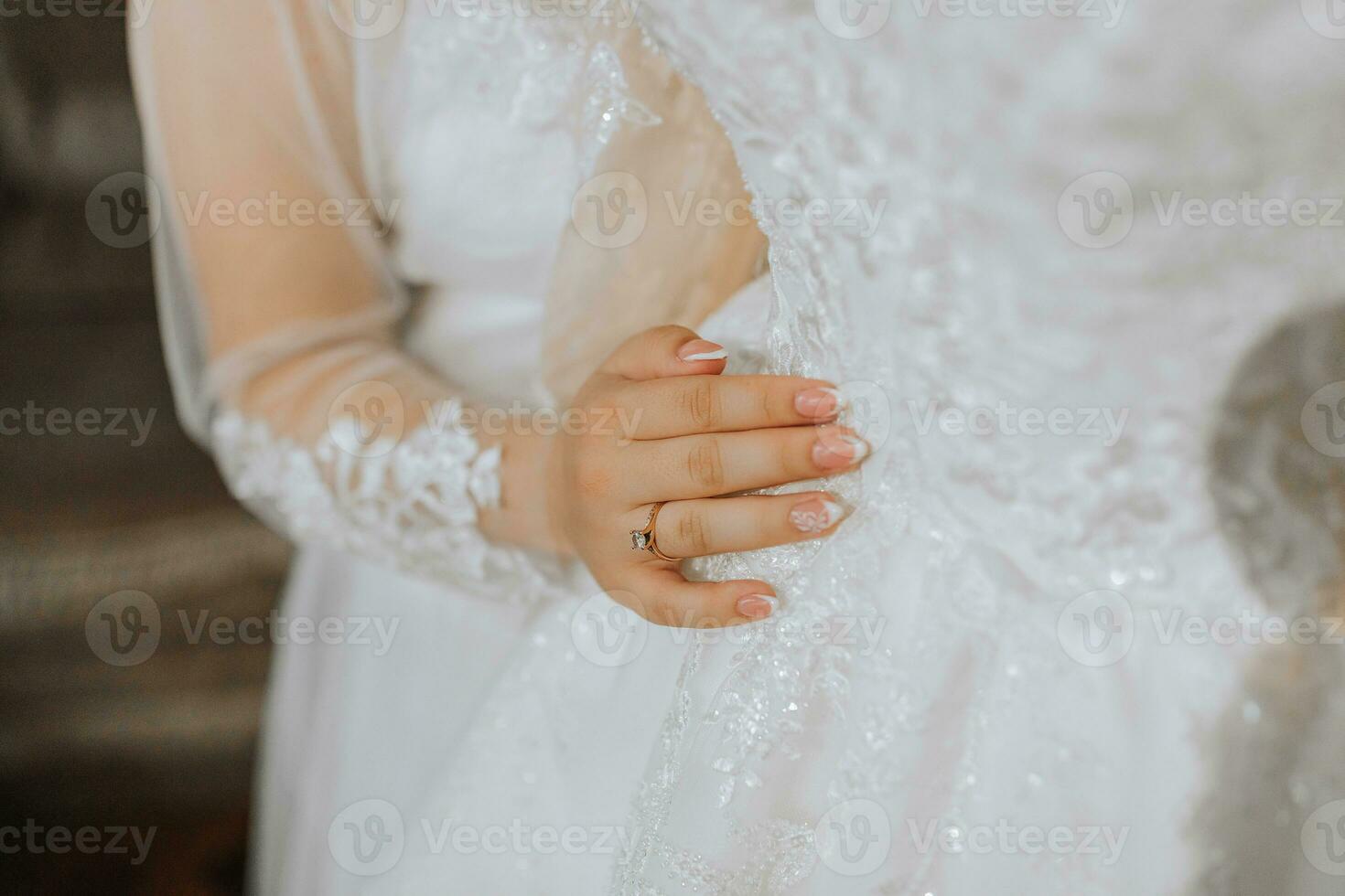 a beautiful girl with a wedding hairstyle in a transparent robe is preparing for a wedding in a hotel with a royal interior. The bride poses next to her wedding dress on a mannequin photo