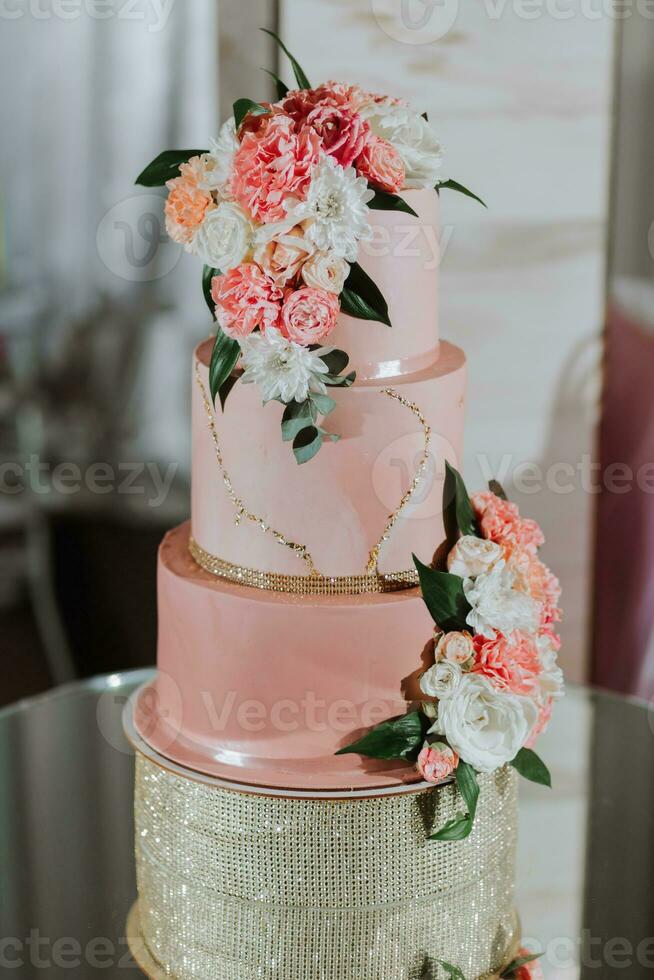 A delicious wedding. three-tiered cake decorated with flowers. Candy bar for a banquet. Celebration concept. Fashionable desserts. Table with sweets, candies. Fruits photo