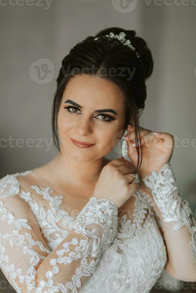 el novia usa hermosa Boda pendientes. niña con peinado y profesional maquillaje usa joyería accesorios foto