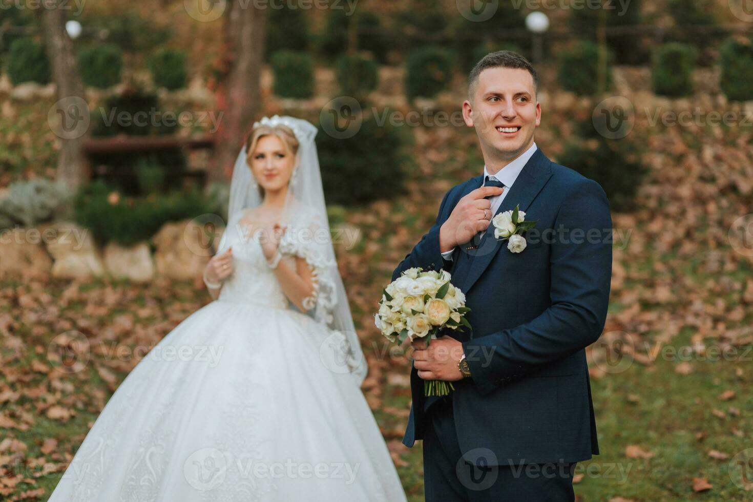 portrait of an elegant wedding couple tenderly embracing in a forest or park. luxury bride and groom embracing. romantic sensual moment photo