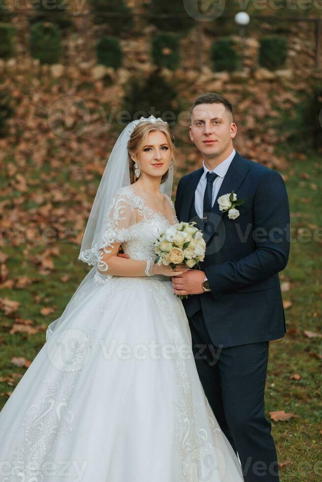 retrato de un elegante Boda Pareja tiernamente abrazando en un bosque o parque. lujo novia y novio abrazando romántico sensual momento foto