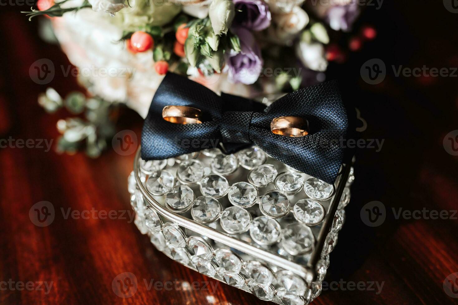 Groom's accessories in the morning. Gold wedding rings, black shirt cufflinks, bow tie photo