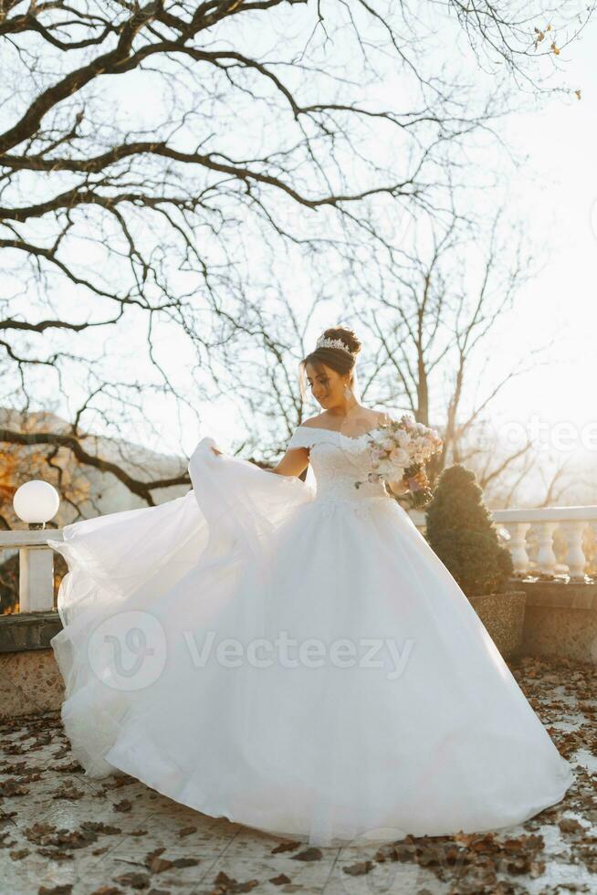 The bride portrait in the autumn forest. Bride in wedding dress on natural background. Wedding day. photo