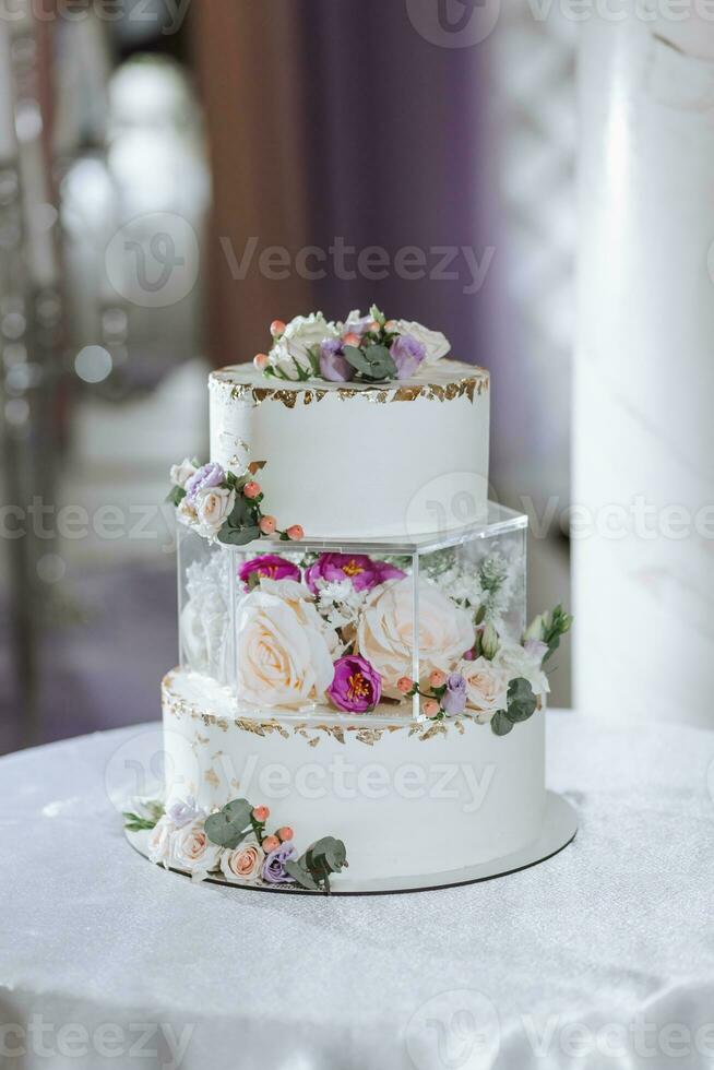 A delicious wedding. three-tiered cake decorated with flowers. Candy bar for a banquet. Celebration concept. Fashionable desserts. Table with sweets, candies. Fruits photo