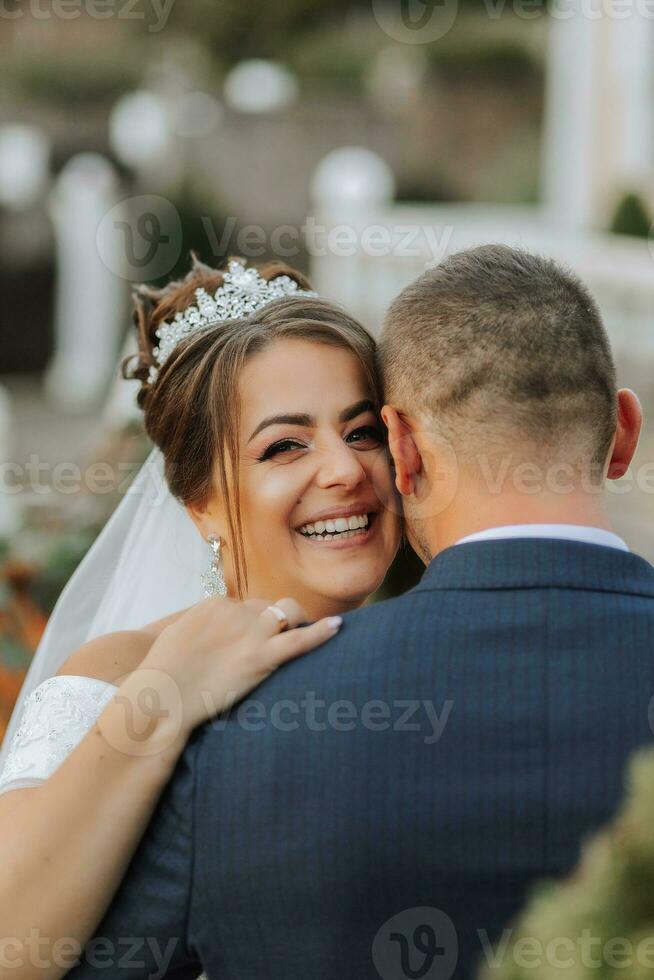 portrait of a happy wedding couple, bride and groom kissing in the autumn forest, park. Happy and smiling bride hugs groom photo