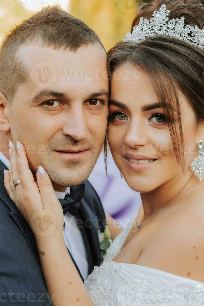 retrato de contento Boda pareja, novia y novio en otoño bosque, parque posando cerca Roca escaleras. un hombre en un traje, un niña en un Boda vestido. novio Besos su novia. foto desde encima