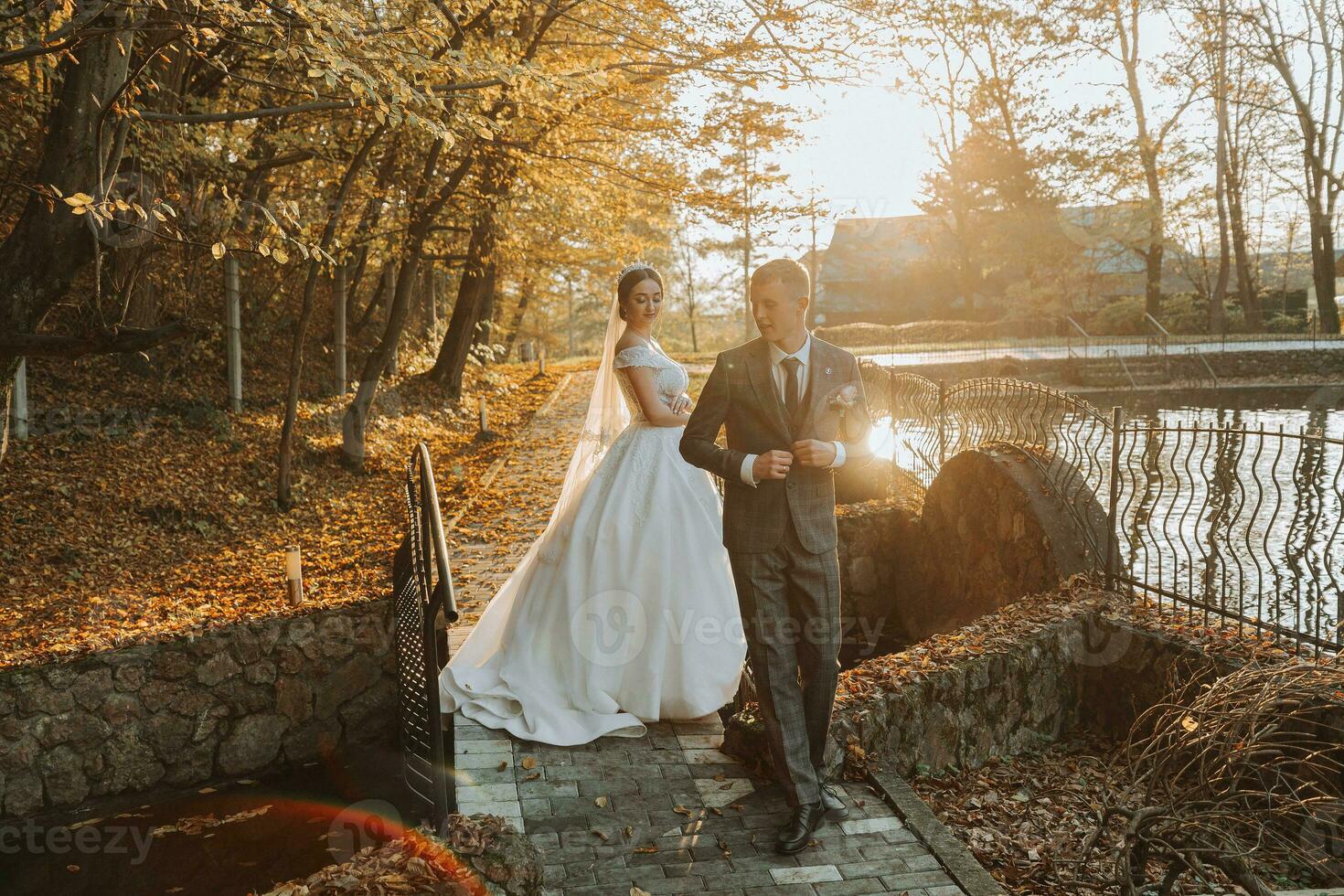 portrait of a happy wedding couple, the bride and groom are walking and kissing in the autumn forest, park photo