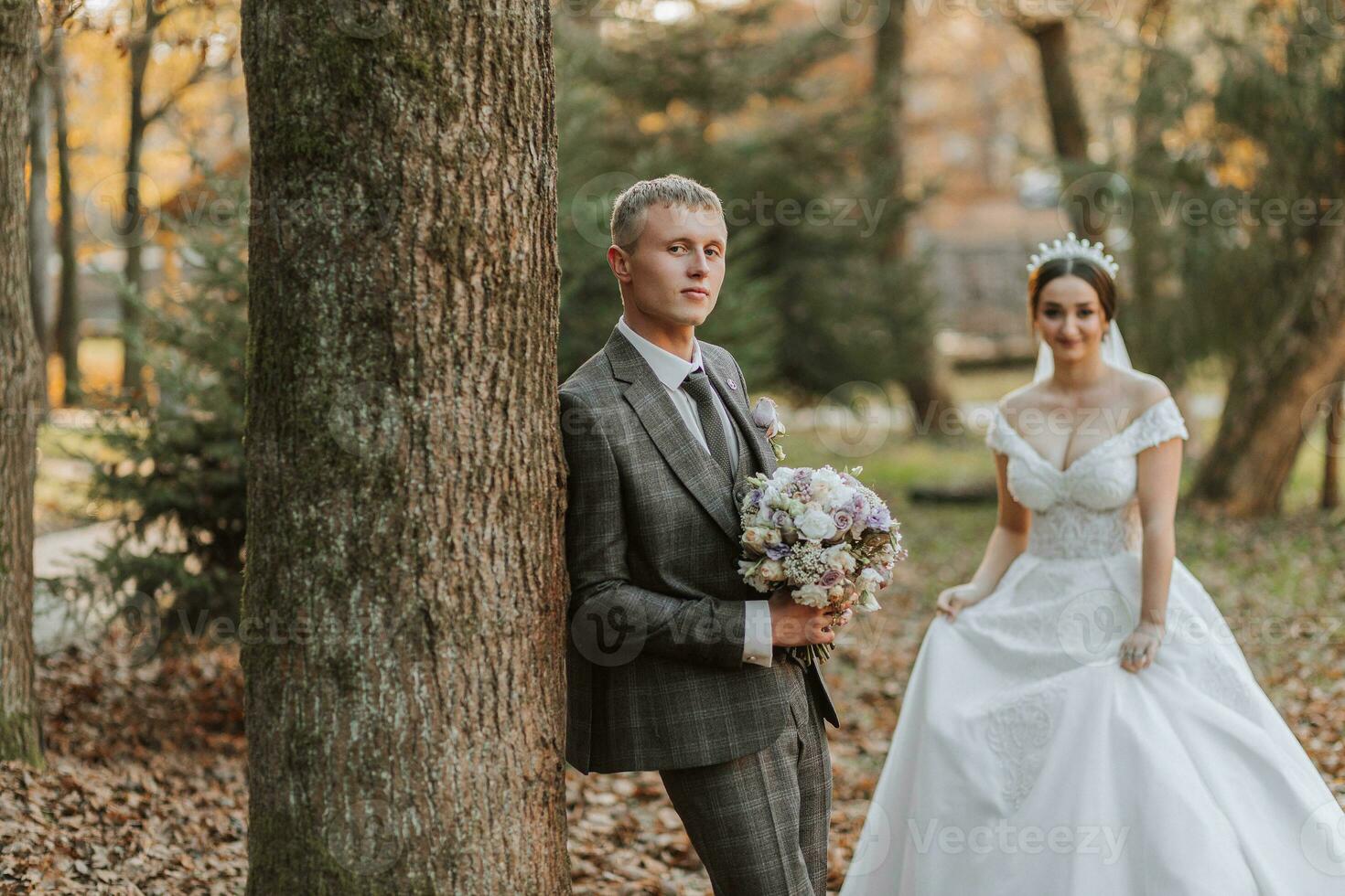 Portrait of the bride and groom in nature, a beautiful couple in love. Autumn tree leaves. The newlyweds are walking in the autumn park photo