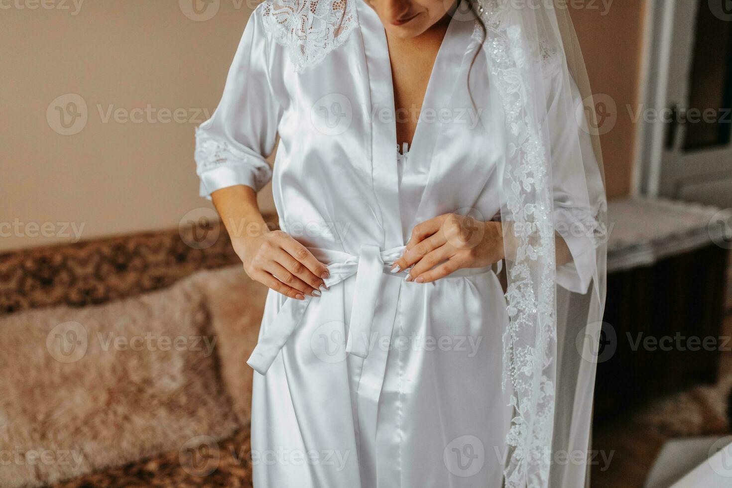 The bride in morning silk in her room. The bride is preparing for her wedding photo