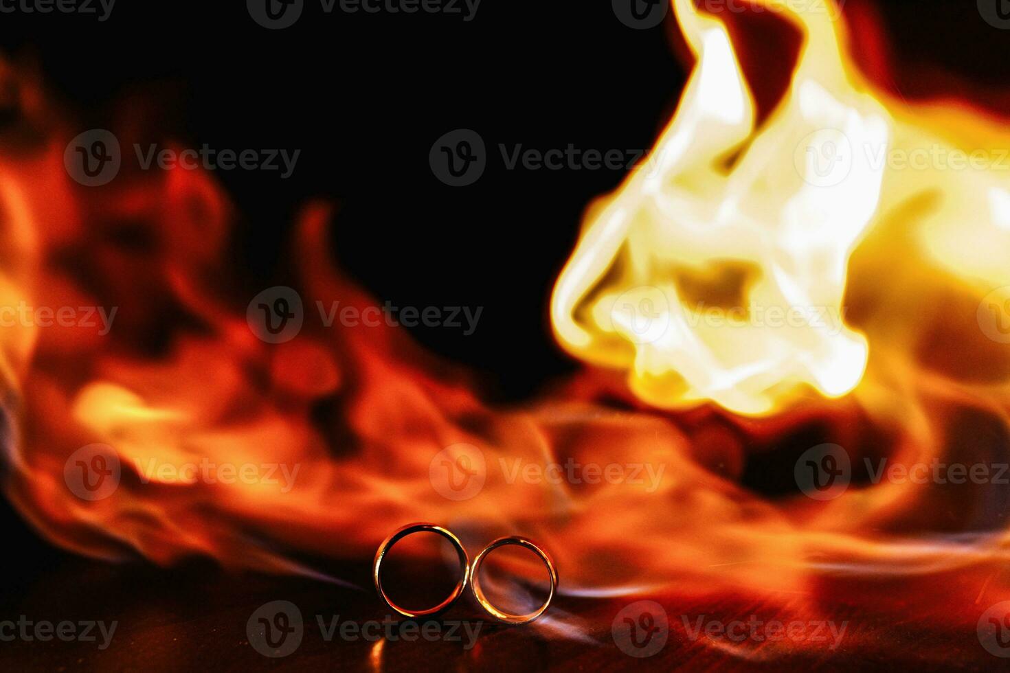 two wedding rings in a flame of fire on a dark background. Wedding. Traditions. photo