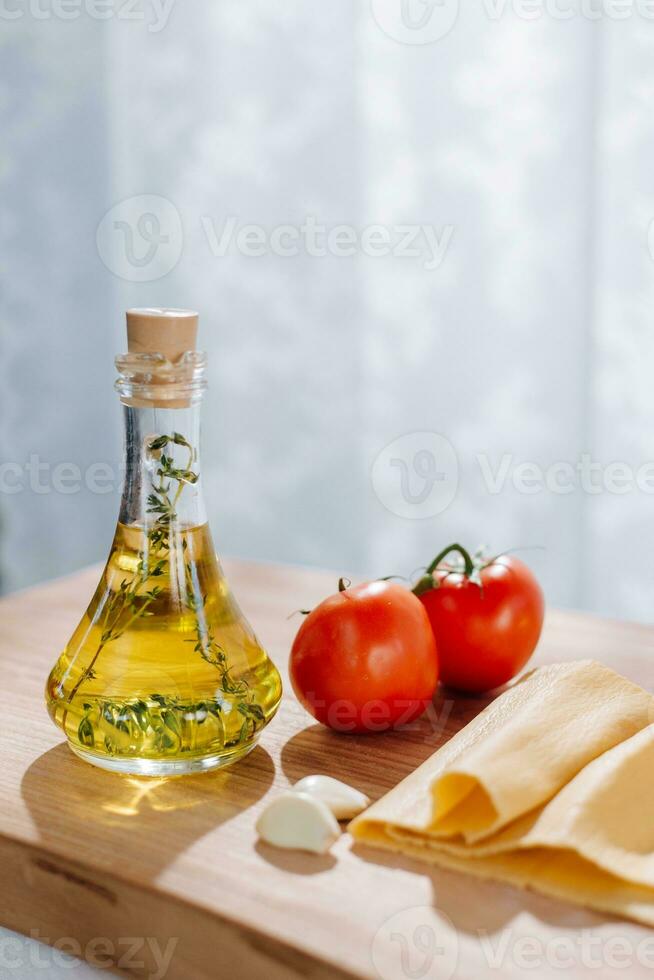 aceituna aceite, tomate, ajo y orégano en un de madera tablero foto