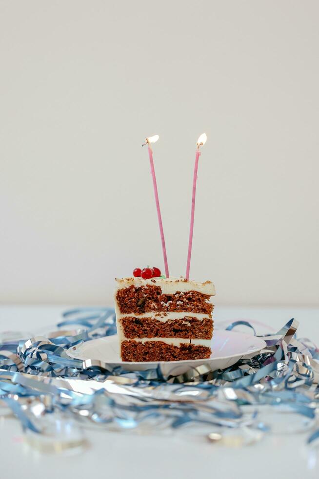 Birthday cake with candles and tinsel on white background. Selective focus. photo