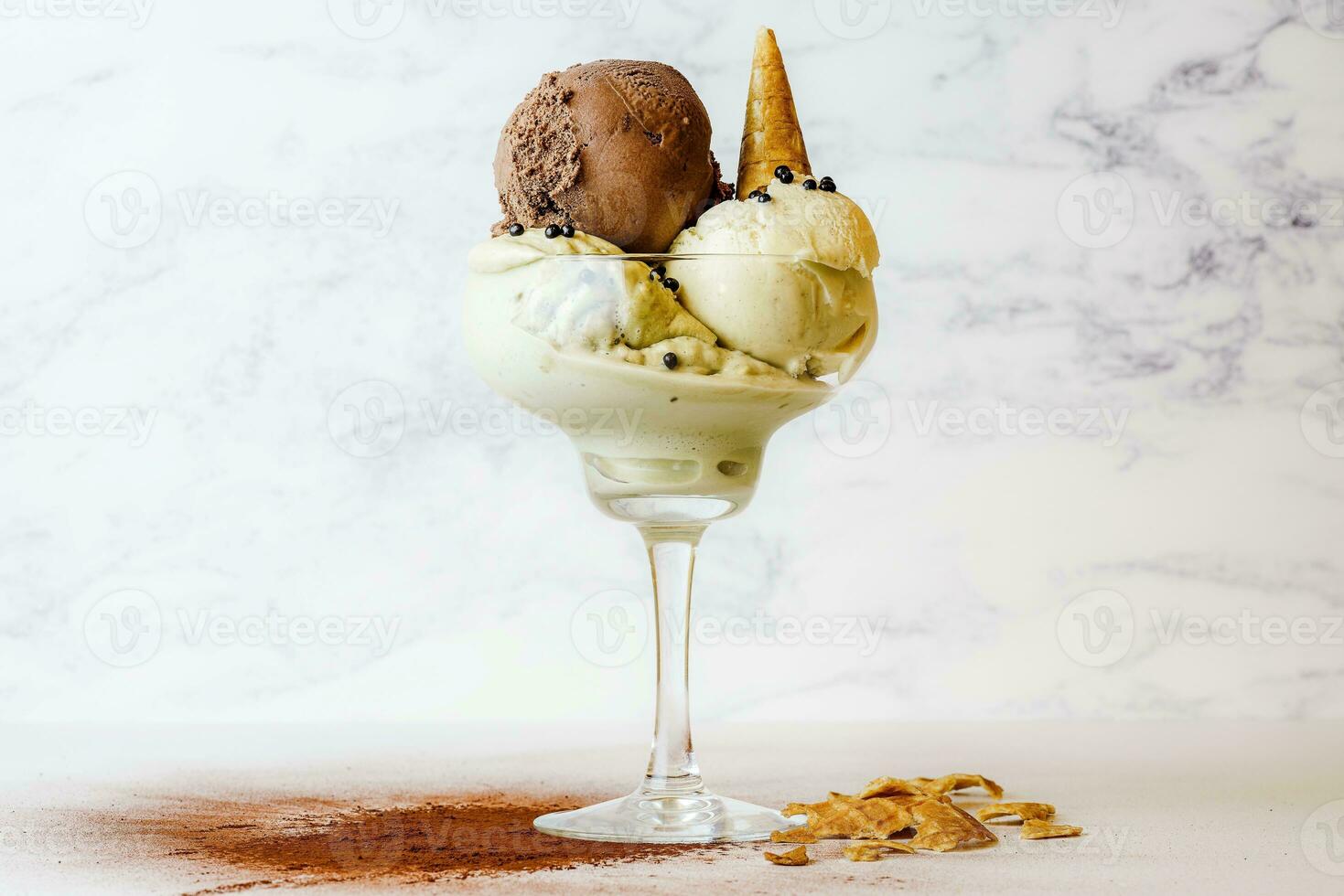 vanilla ice cream with chocolate, vanilla and hazelnut in glassle background photo
