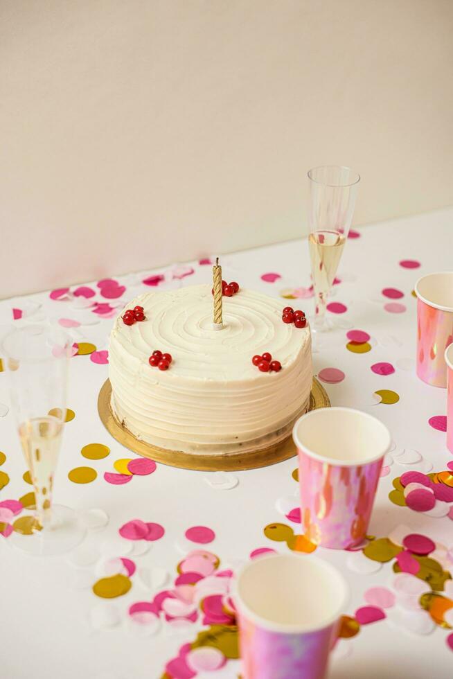 Birthday cake with candles, cup of champagne and rose petals photo