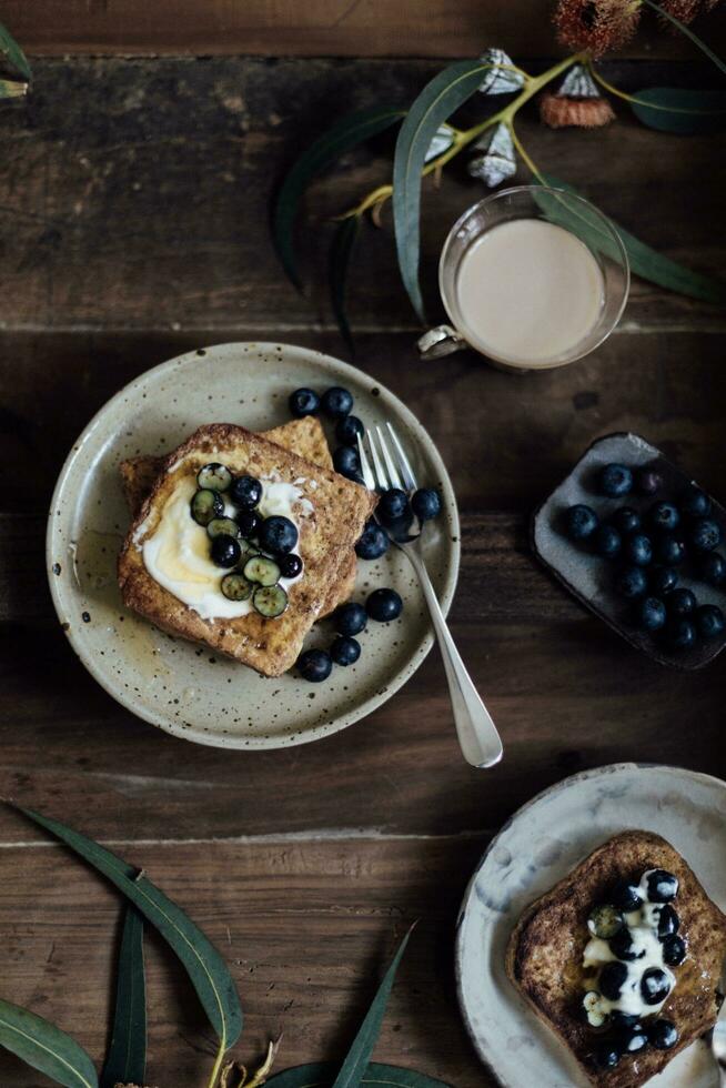 French toast with blueberries and milk on wooden table, top view photo