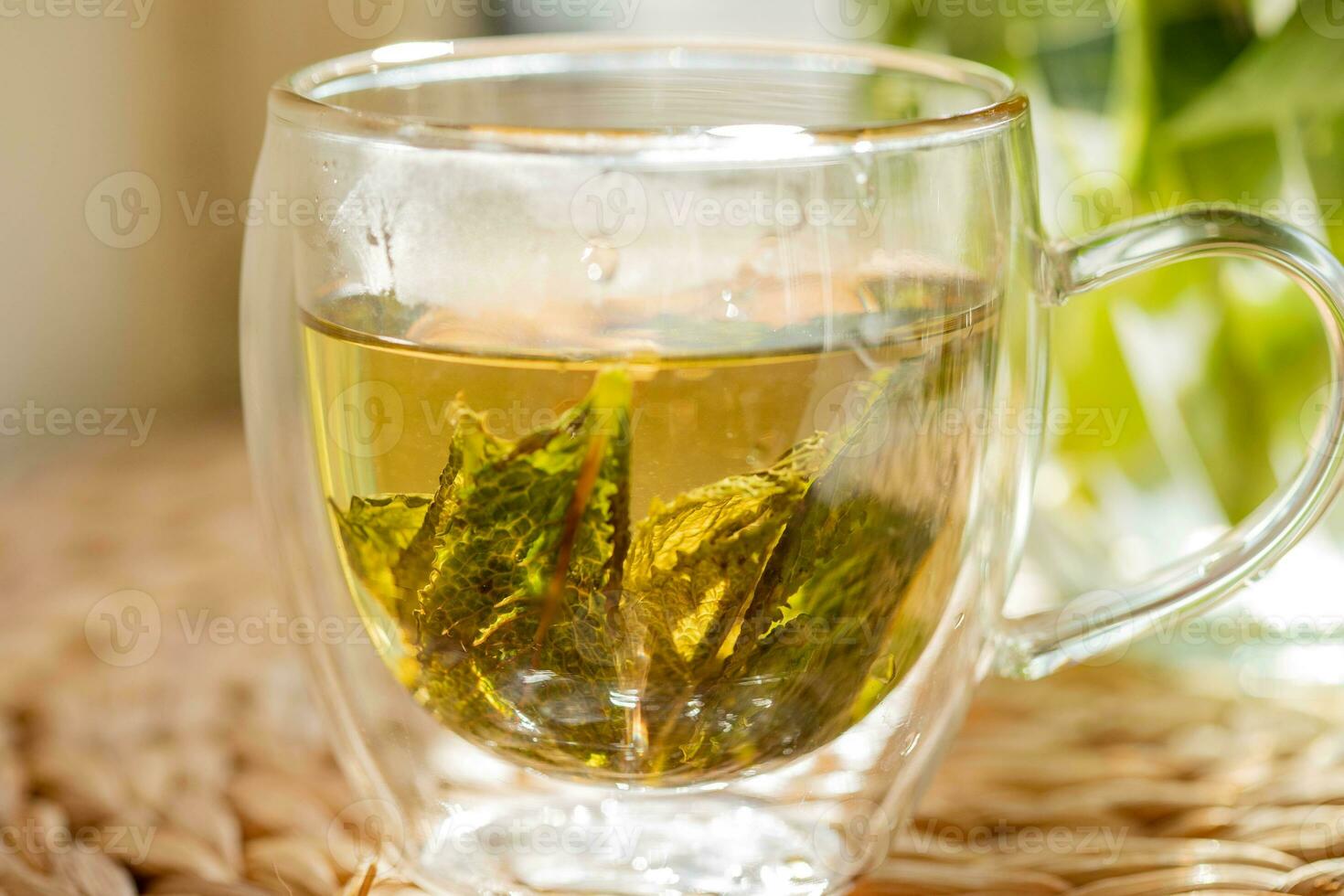 Green tea in a glass cup and teapot on the windowsill photo