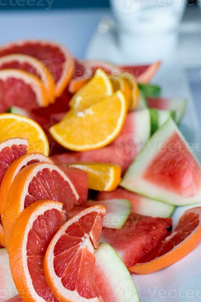 Close up of different kinds of citrus fruit on a white plate. photo