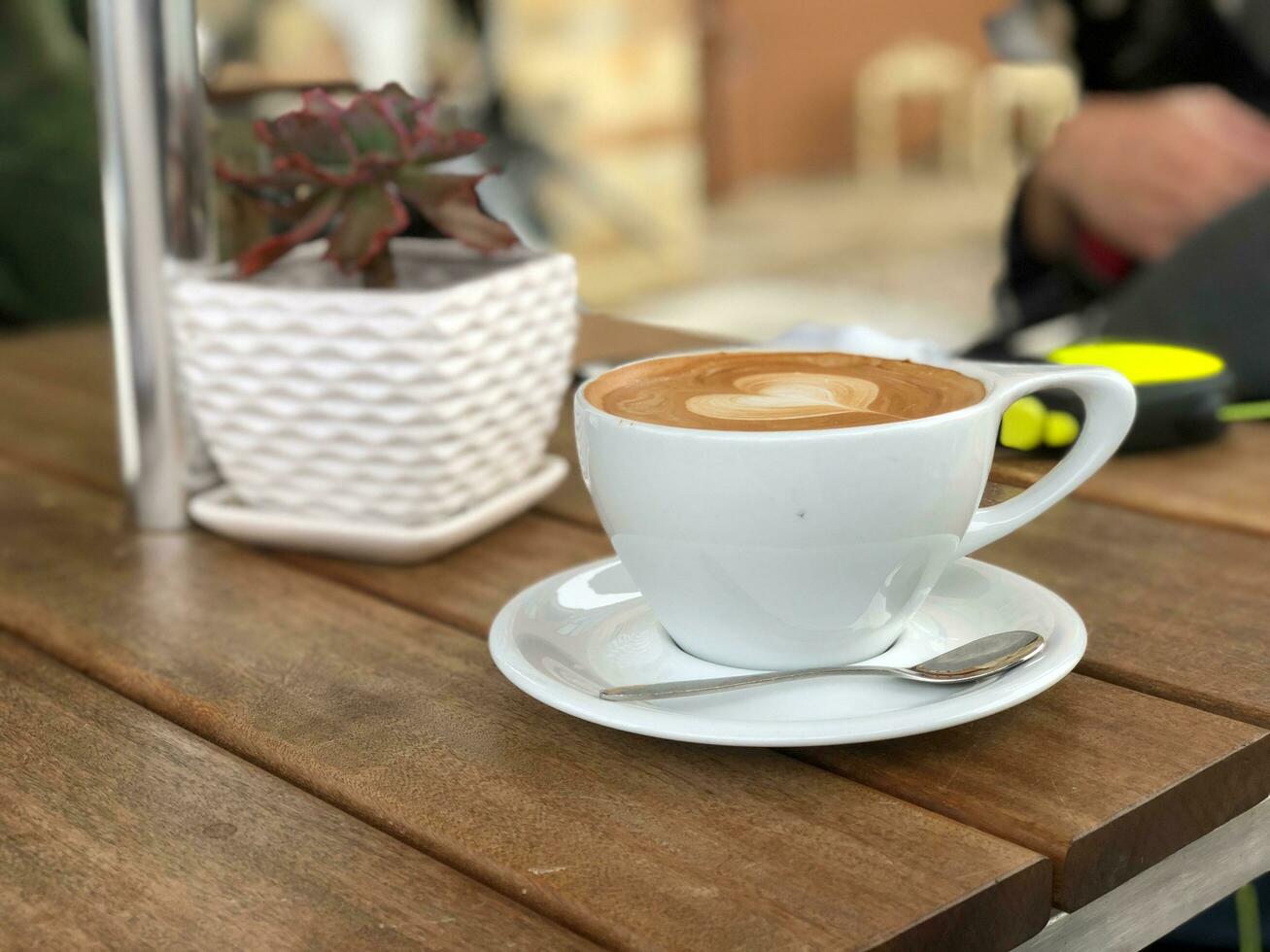 Coffee cup on wooden table in coffee shop, stock photo