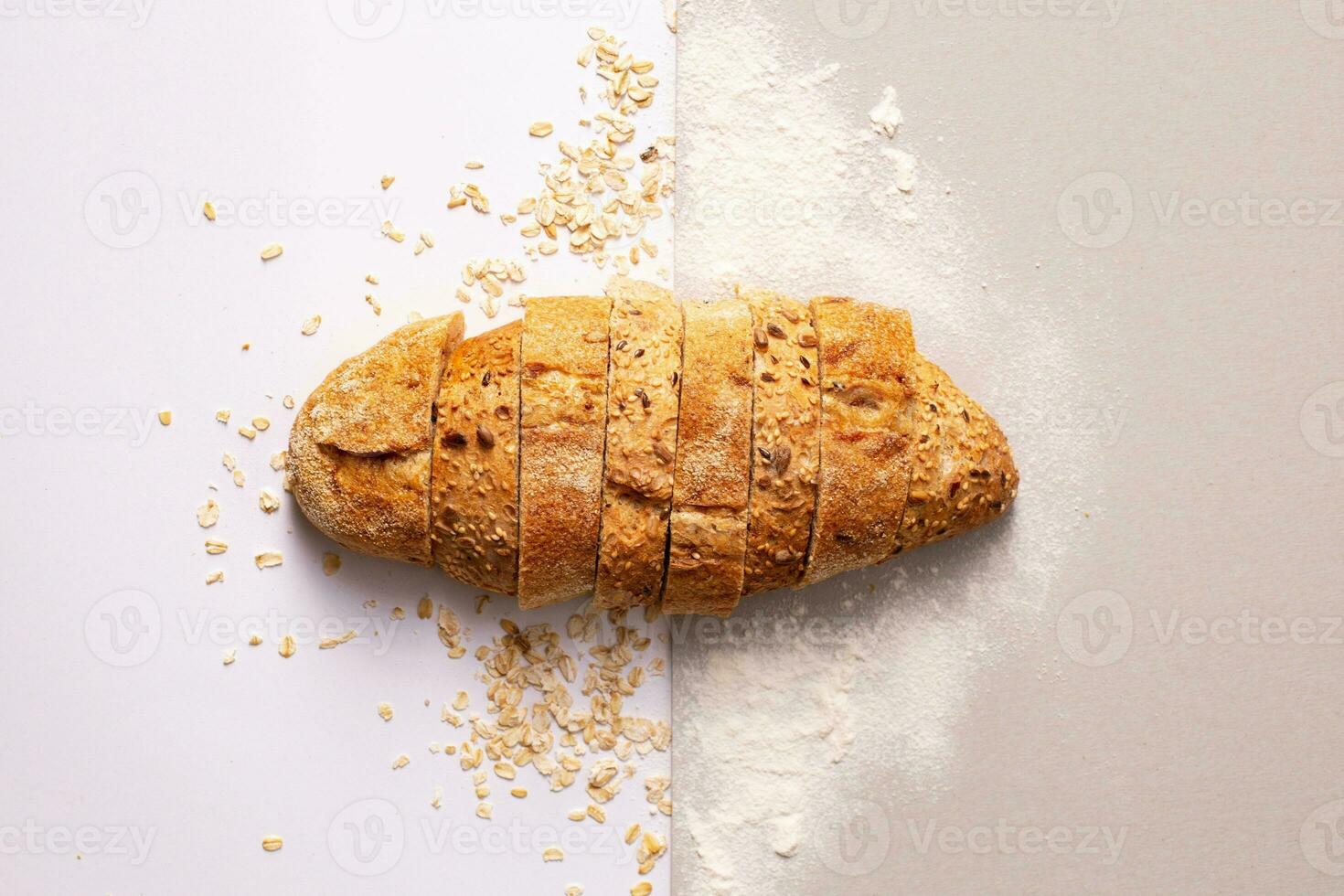 Loaf of bread with cereals on white background, top view photo