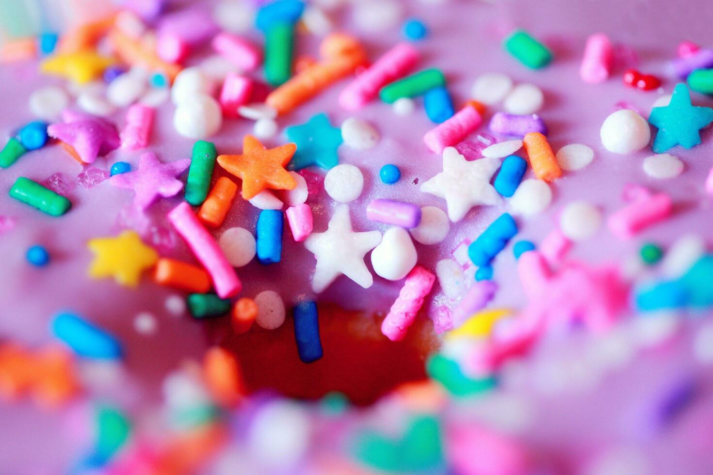 Rainbow cake with colorful sprinkles on a pink background. Selective focus. photo