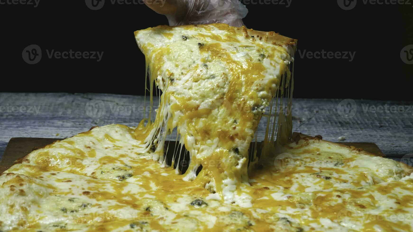 Close-up of man takes delicious slice of pizza with cheese. Frame. Man takes piece of Italian pizza and pulls appetizing melted cheese photo