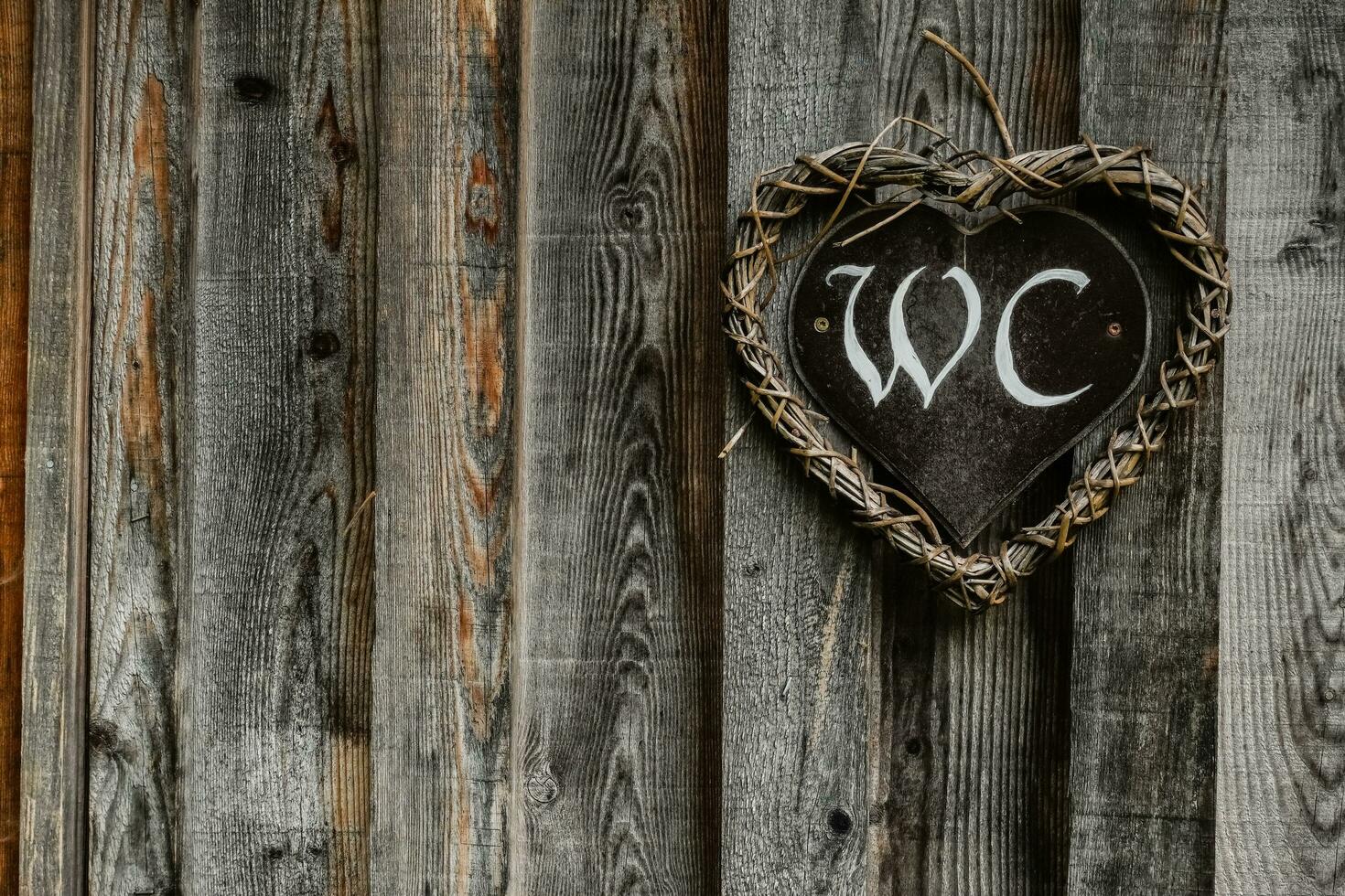 handmade sign for toilet on a wooden door in the nature photo