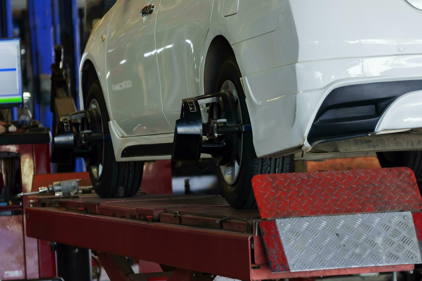 Car wheel alignment service in a car repair shop. Automation sensor equipment maintenance business photo