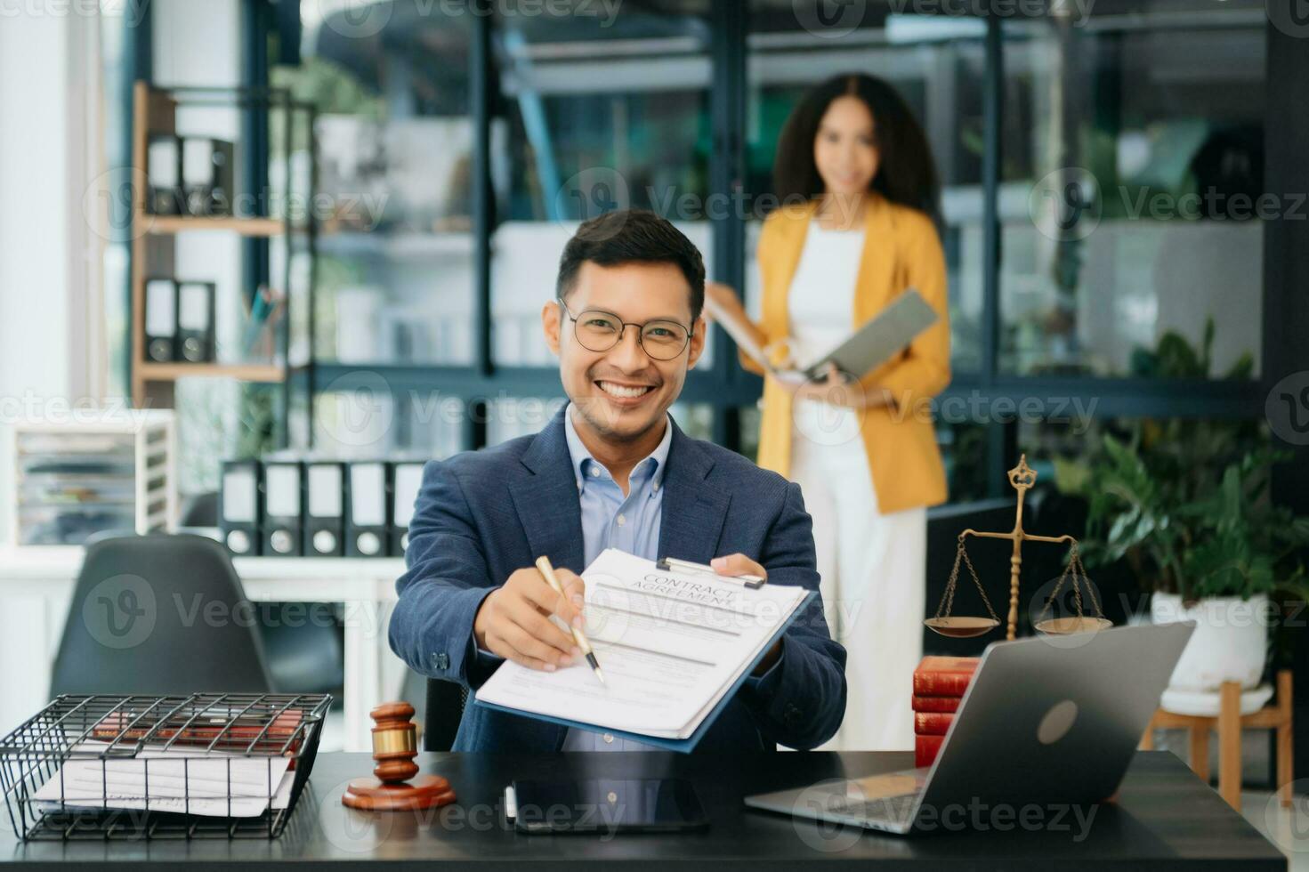 Attractive young lawyer in office Business man and lawyers discussing contract papers laptop and tablet with brass scale on  desk i photo