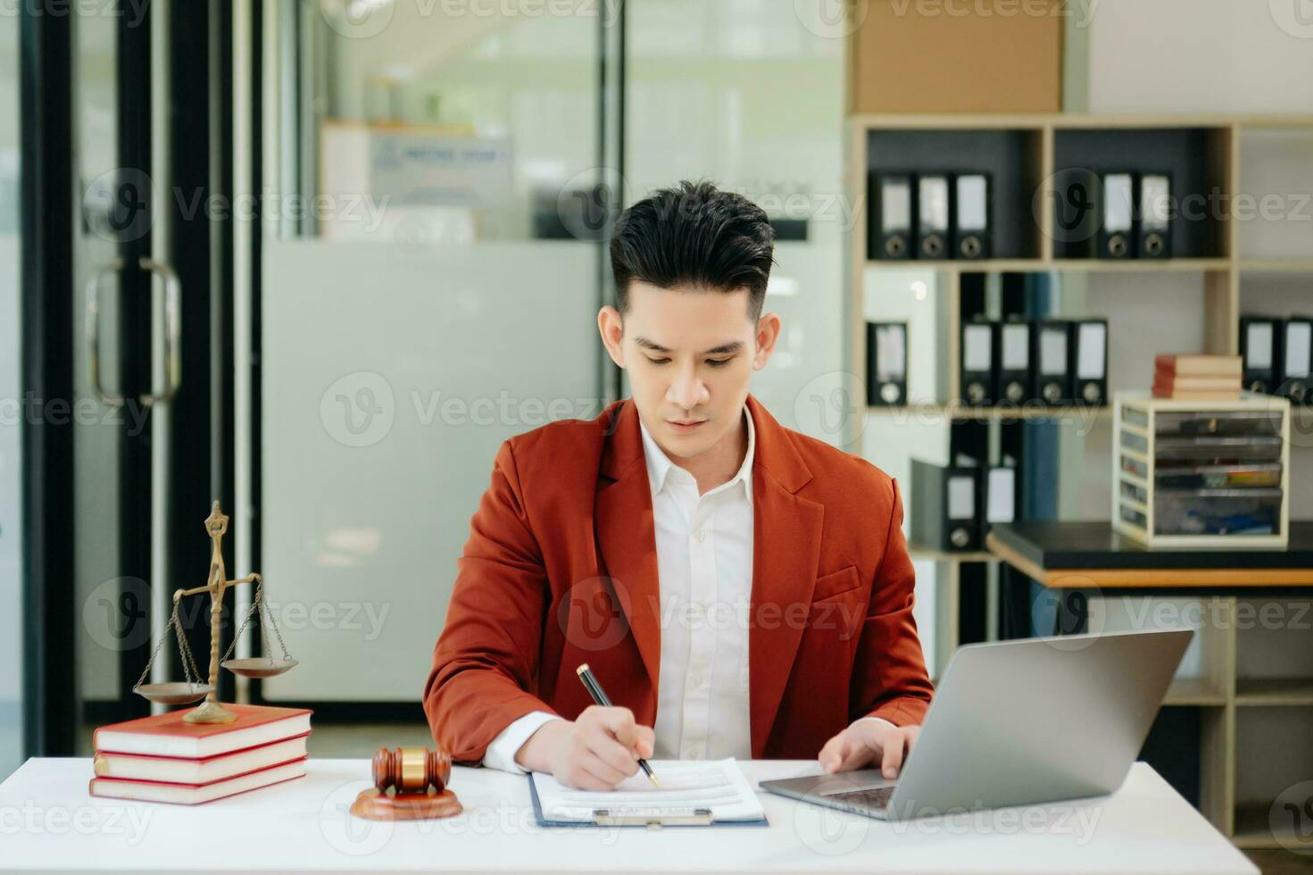 justice and law concept. Asian Male judge in a courtroom the gavel, working with smart phone and laptop and digital tablet computer photo