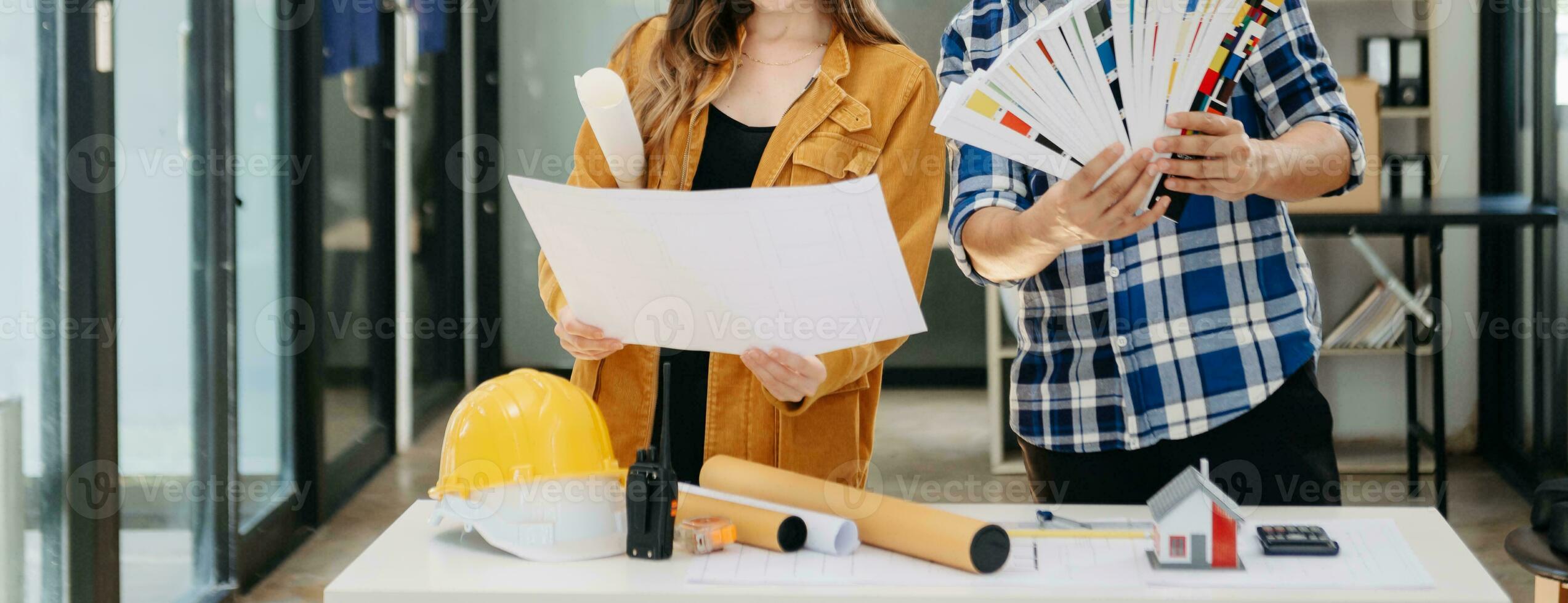 Engineer teams meeting working together wear worker helmets hardhat with on architectural project site and making model house. photo