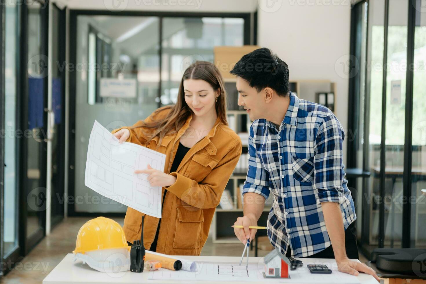 Engineer teams meeting working together wear worker helmets hardhat with on architectural project site and making model house. photo