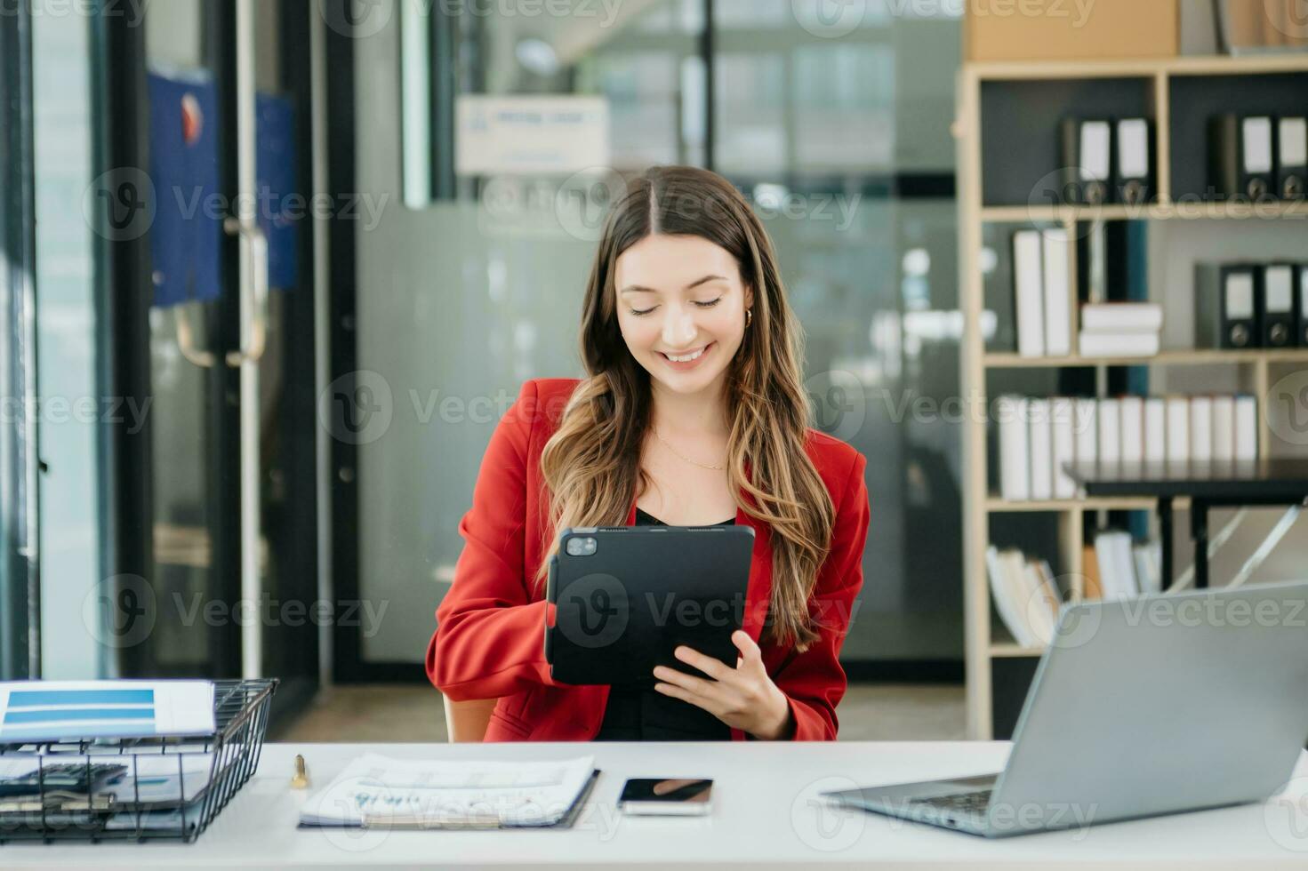 Confident business expert attractive smiling young woman typing laptop and holding digital tablet photo