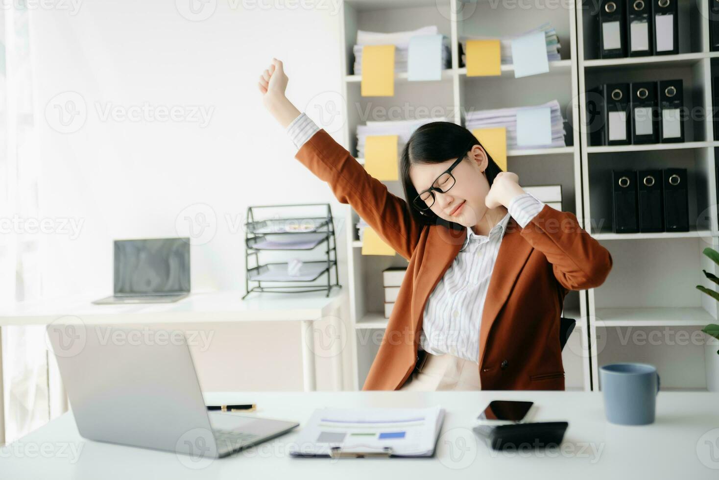 Overworked young Asian businesswoman office worker suffering from neck pain after had a long day at her office desk. photo