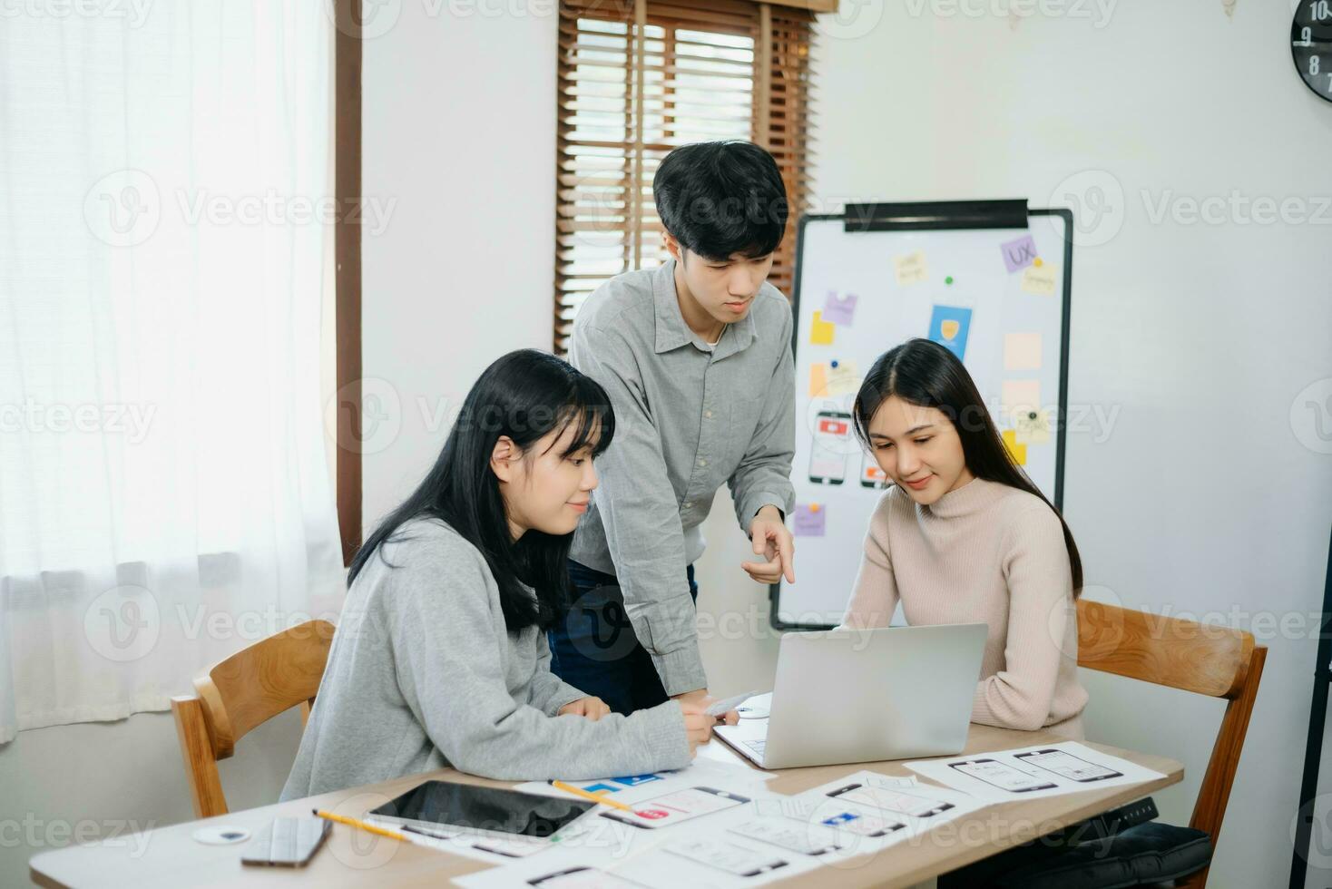 Close up view of UI developer team brainstorming on their project with laptop, smartphone and digital tablet. photo