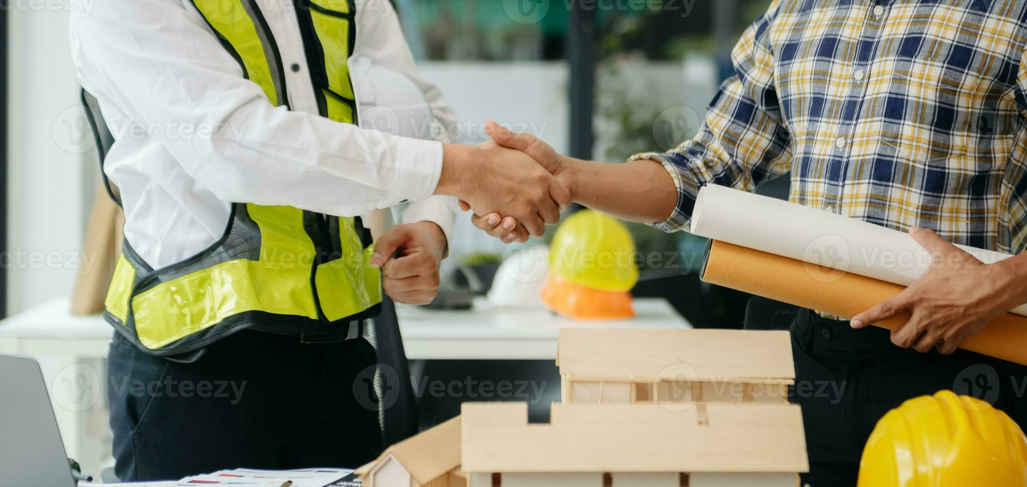 Engineer desk with object paper and tablet with blurry engineer teamwork hardworking to consults about their building project. photo