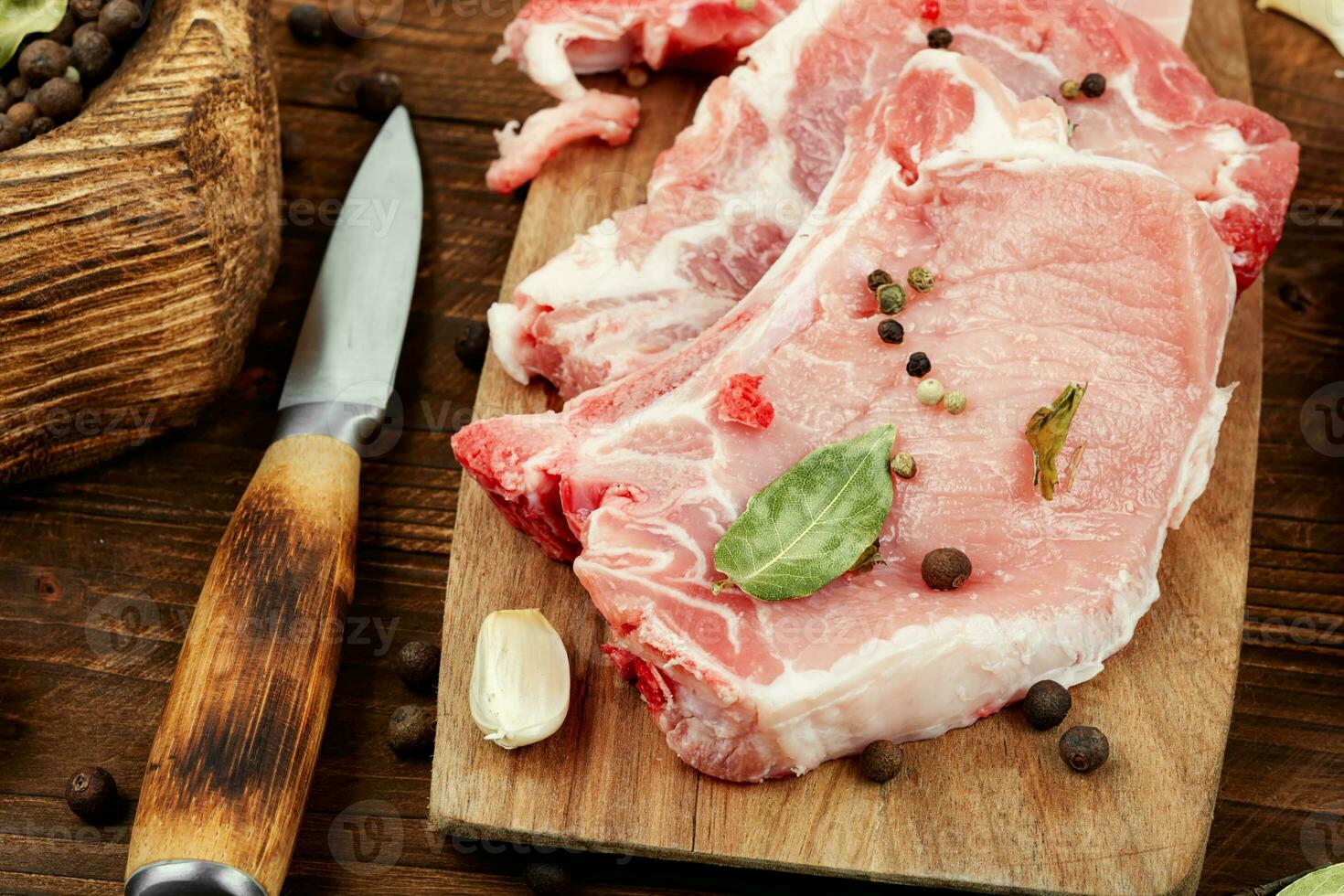 Raw pork steak on a wooden board. photo